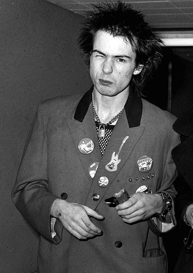 Sid Vicious at Heathrow airport in London – as the band walked to their aircraft, they hurled abuse at reporters and photographers
