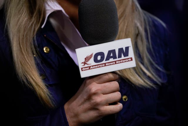 <p>A reporter with One America News Network works at a Donald Trump campaign rally in Virginia in 2020. </p>