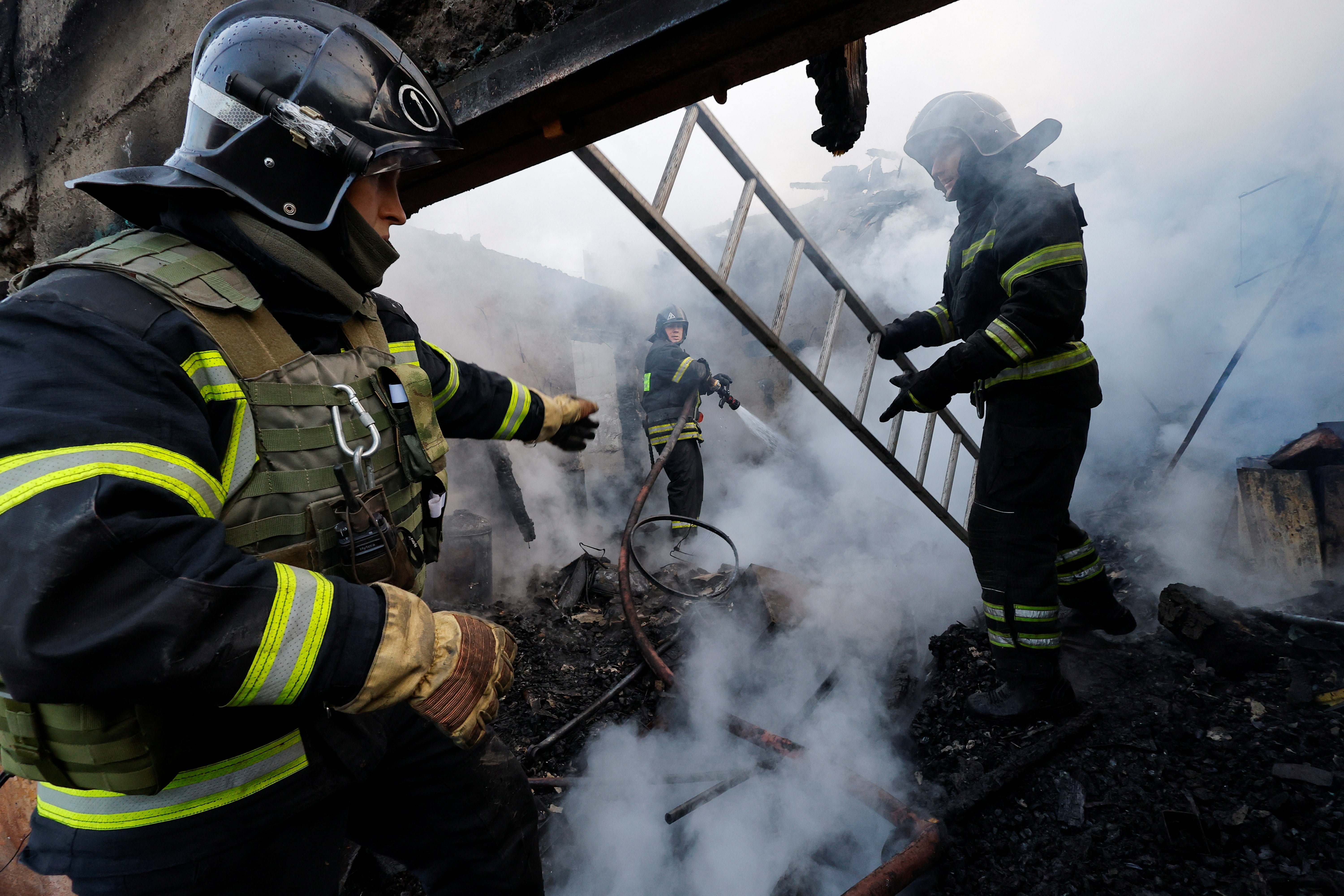 Firefighters work in a destroyed building hit by shelling in a residential area in Donetsk, Russian-controlled Ukraine