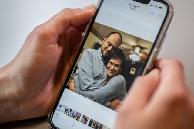 <p>Evgenia Kara-Murza, the wife of Kremlin critic Vladimir Kara-Murza shows a picture of her and her husband on her mobile phone</p>