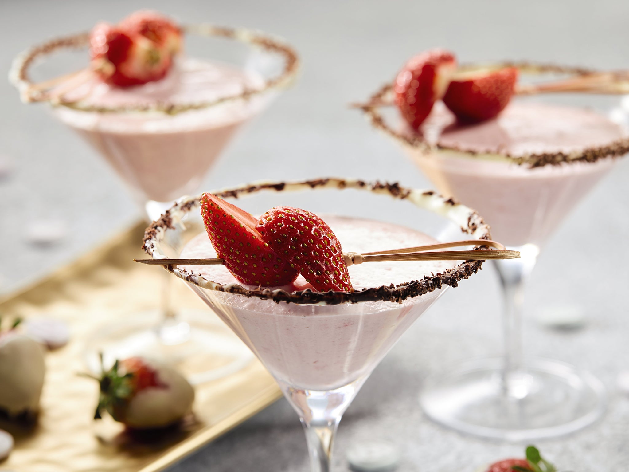 Vanilla martini served with strawberries in a white chocolate dipped cocktail glass