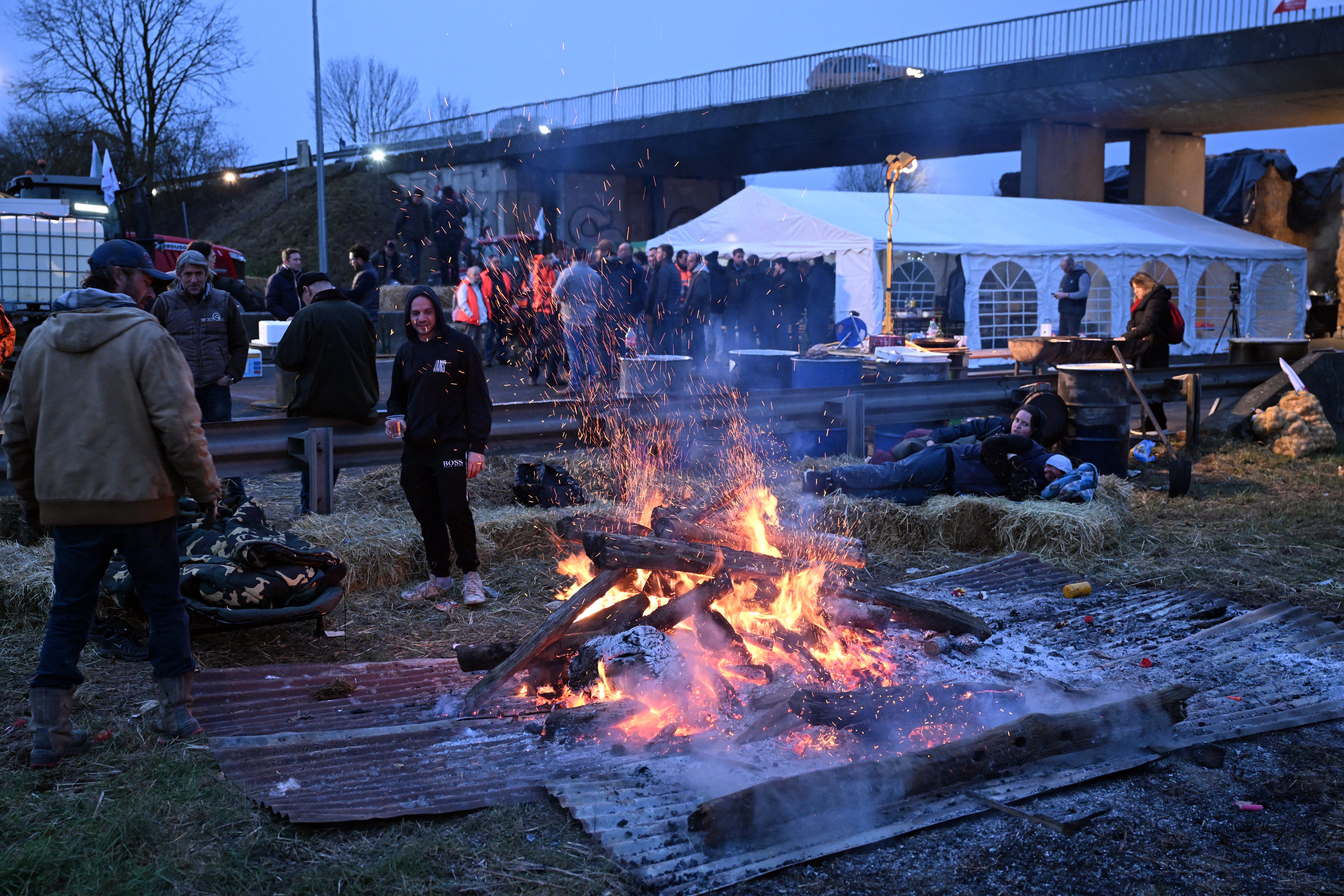 Farmers stay warm at their blockade on the A4 highway near Jossigny