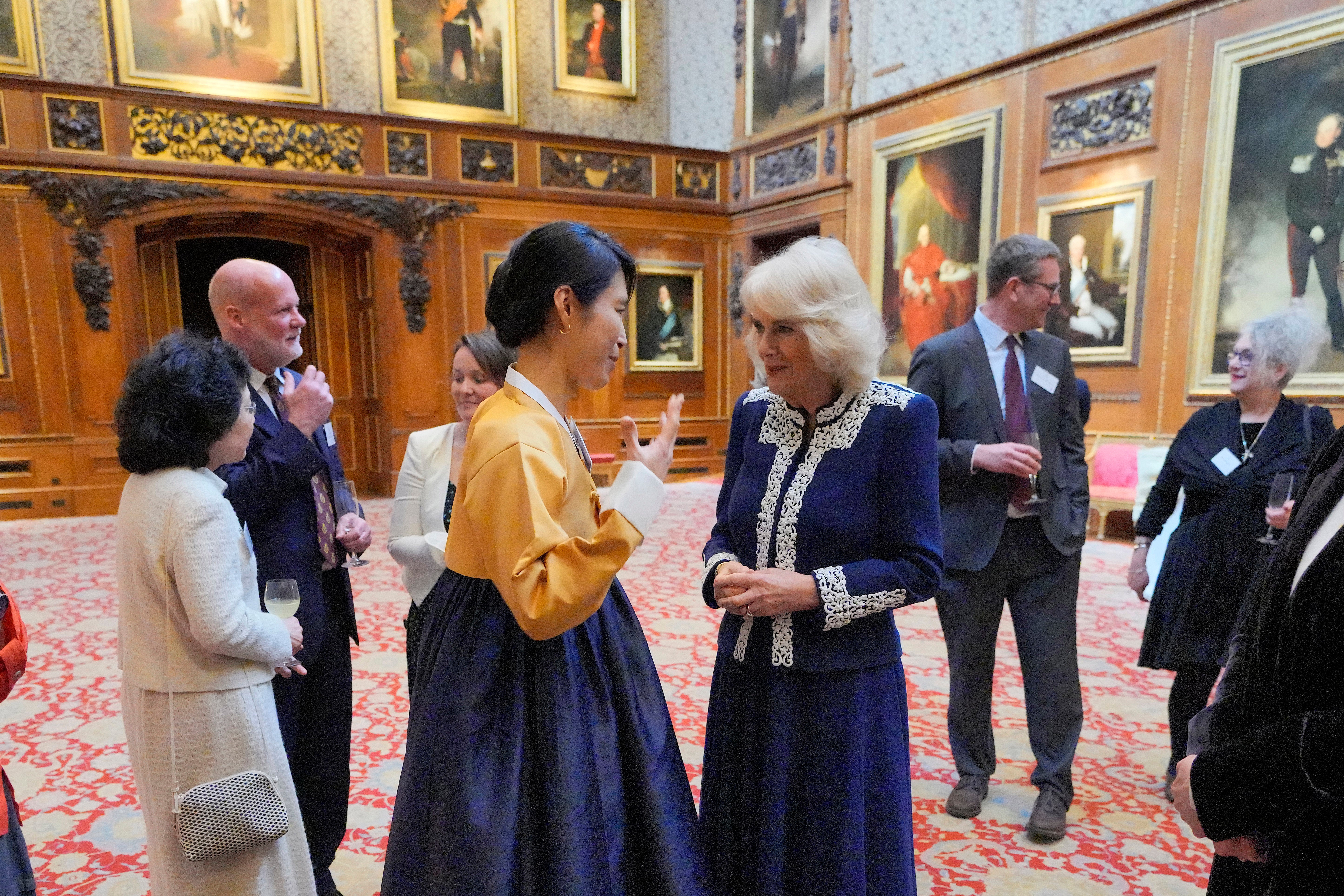 Queen Camilla speaks to Haein Song during a reception at Windsor Castle for authors, illustrators and binders who have been involved in the new Miniature Library collection