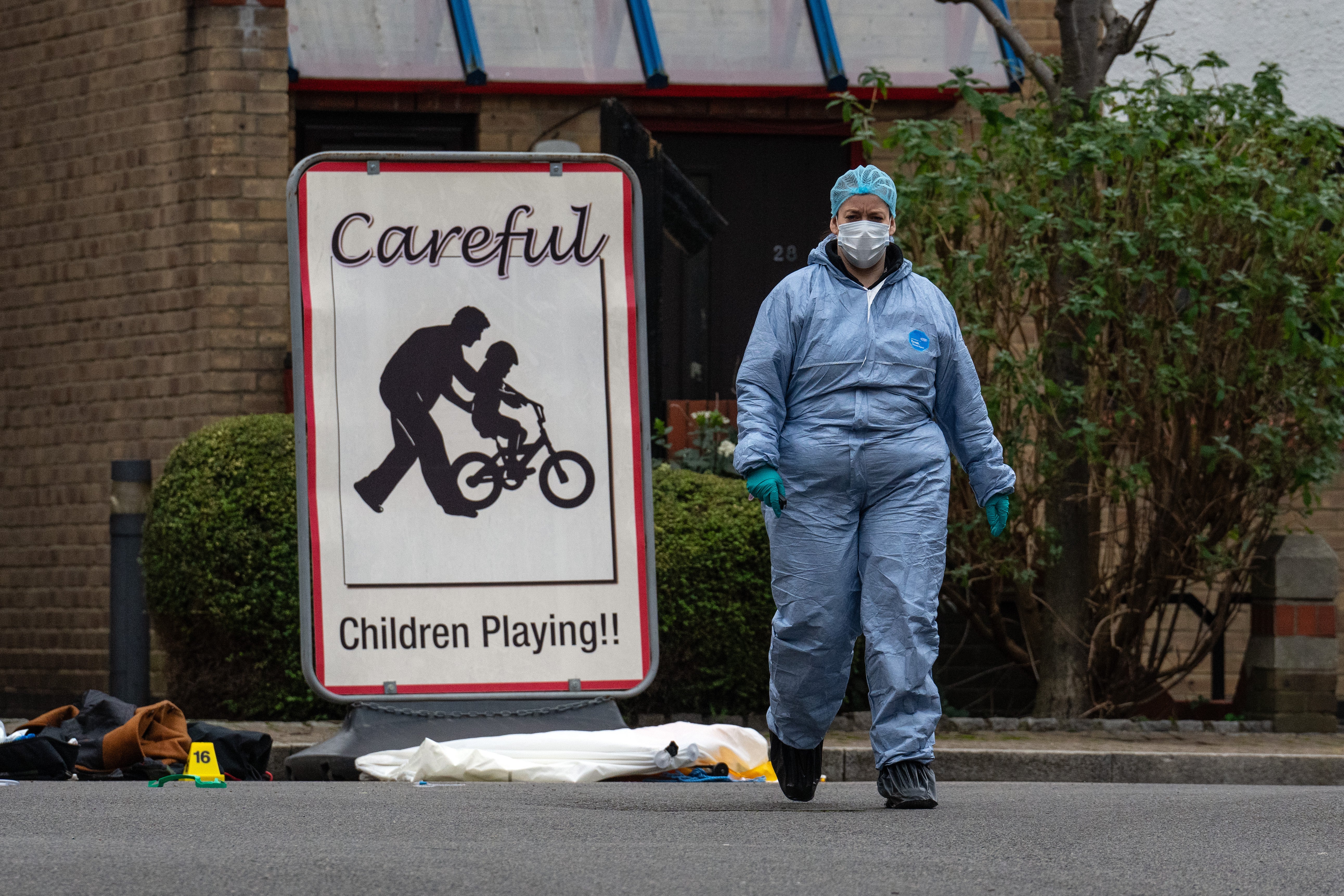 Police and forensics officers work at the scene of a shooting
