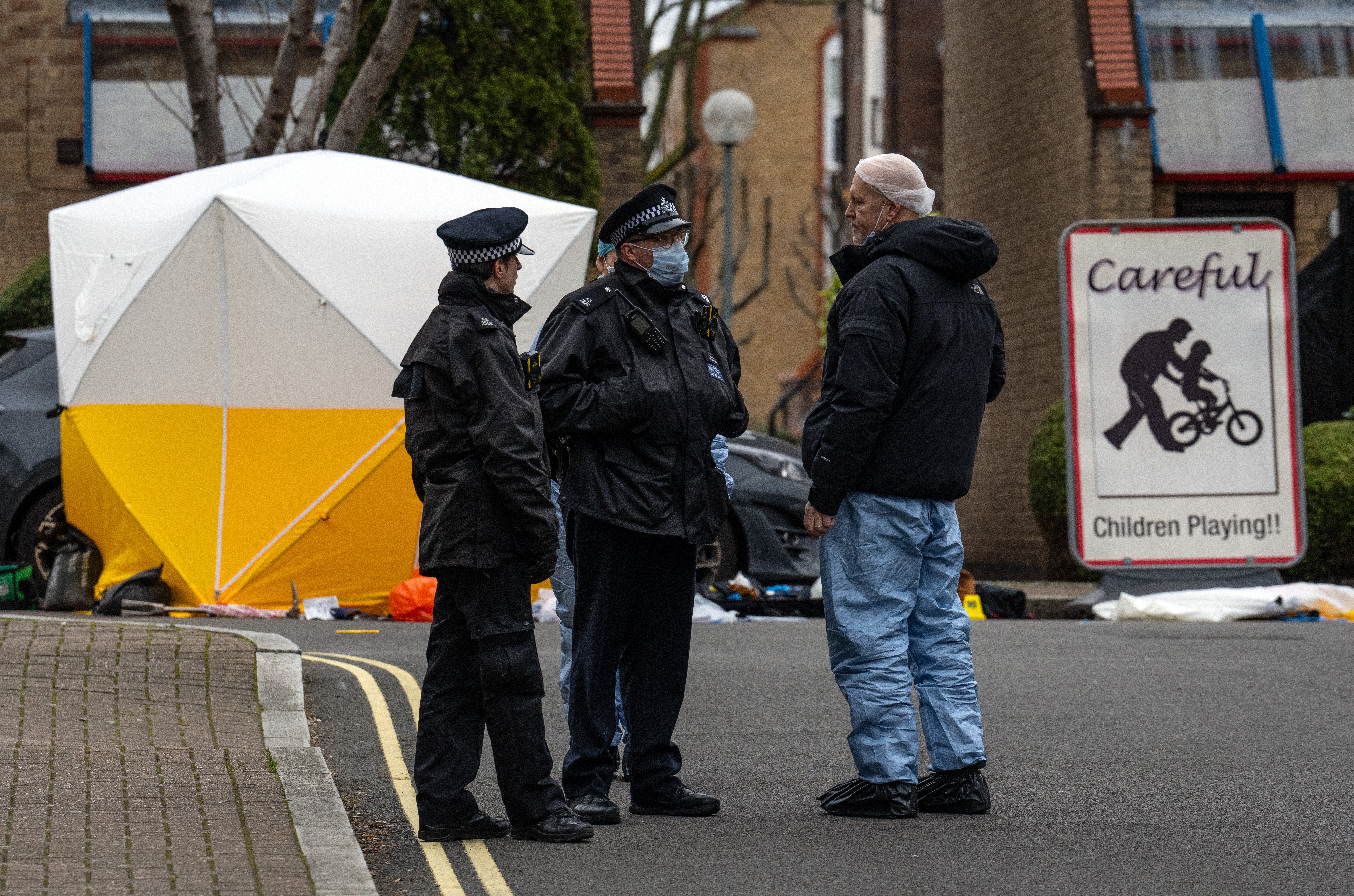 Police talk to local residents after the man was shot dead