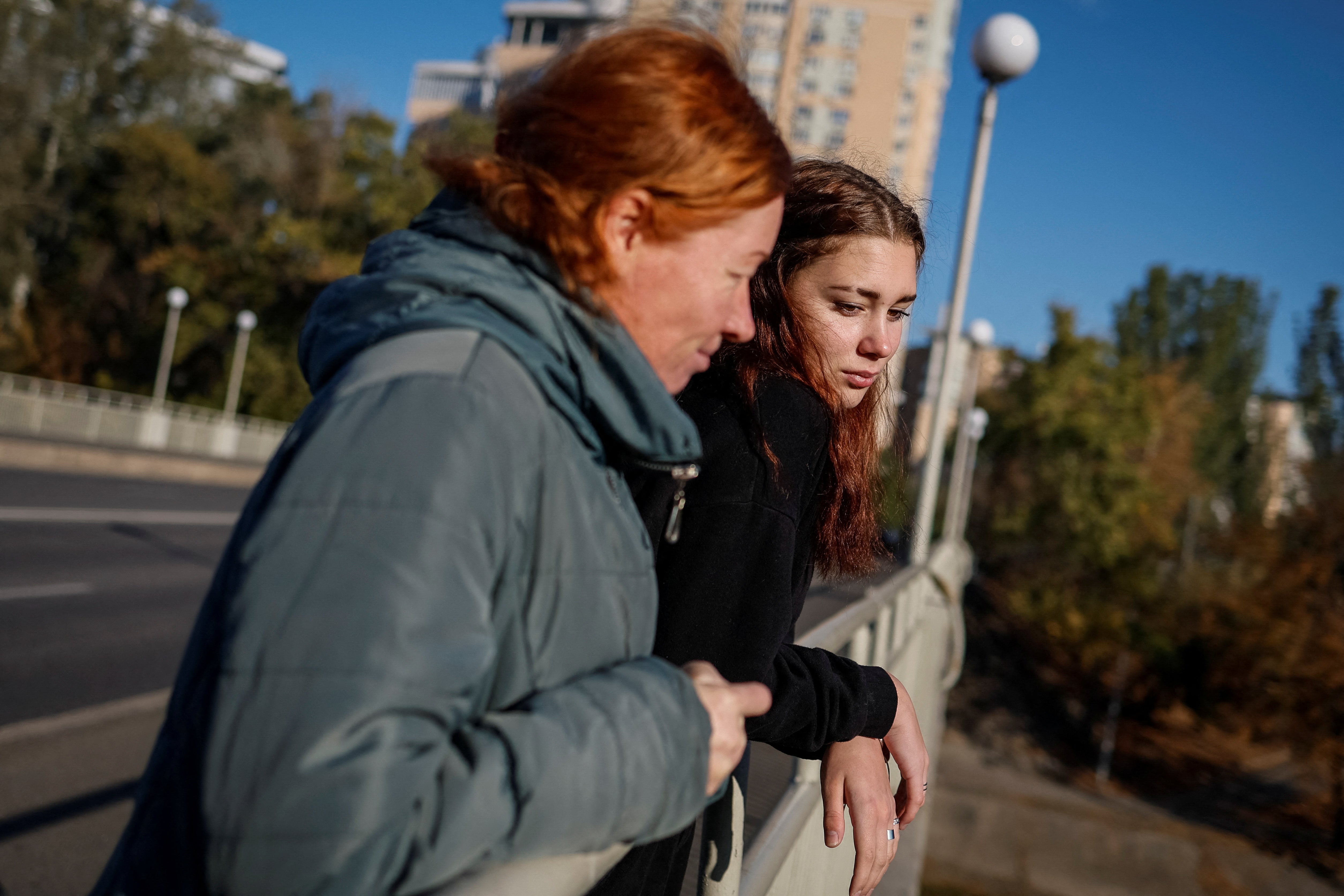 Liza Batsura and her mother Oksana look out from a bridge in Kyiv after the teenager returned to Ukraine