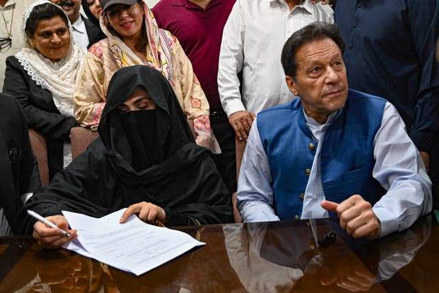 <p>File Pakistan’s former Prime Minister, Imran Khan (R) along with his wife Bushra Bibi (L) looks on as he signs surety bonds for bail in 2023</p>