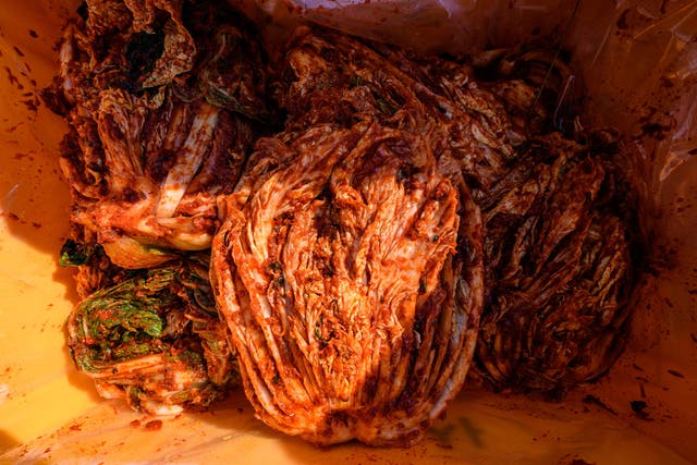 <p>Freshly prepared kimchi, a traditional Korean dish of spicy fermented cabbage and radish, is placed in a box during a kimchi making festival at the Jogyesa Buddhist temple in Seoul on December 2, 2021</p>