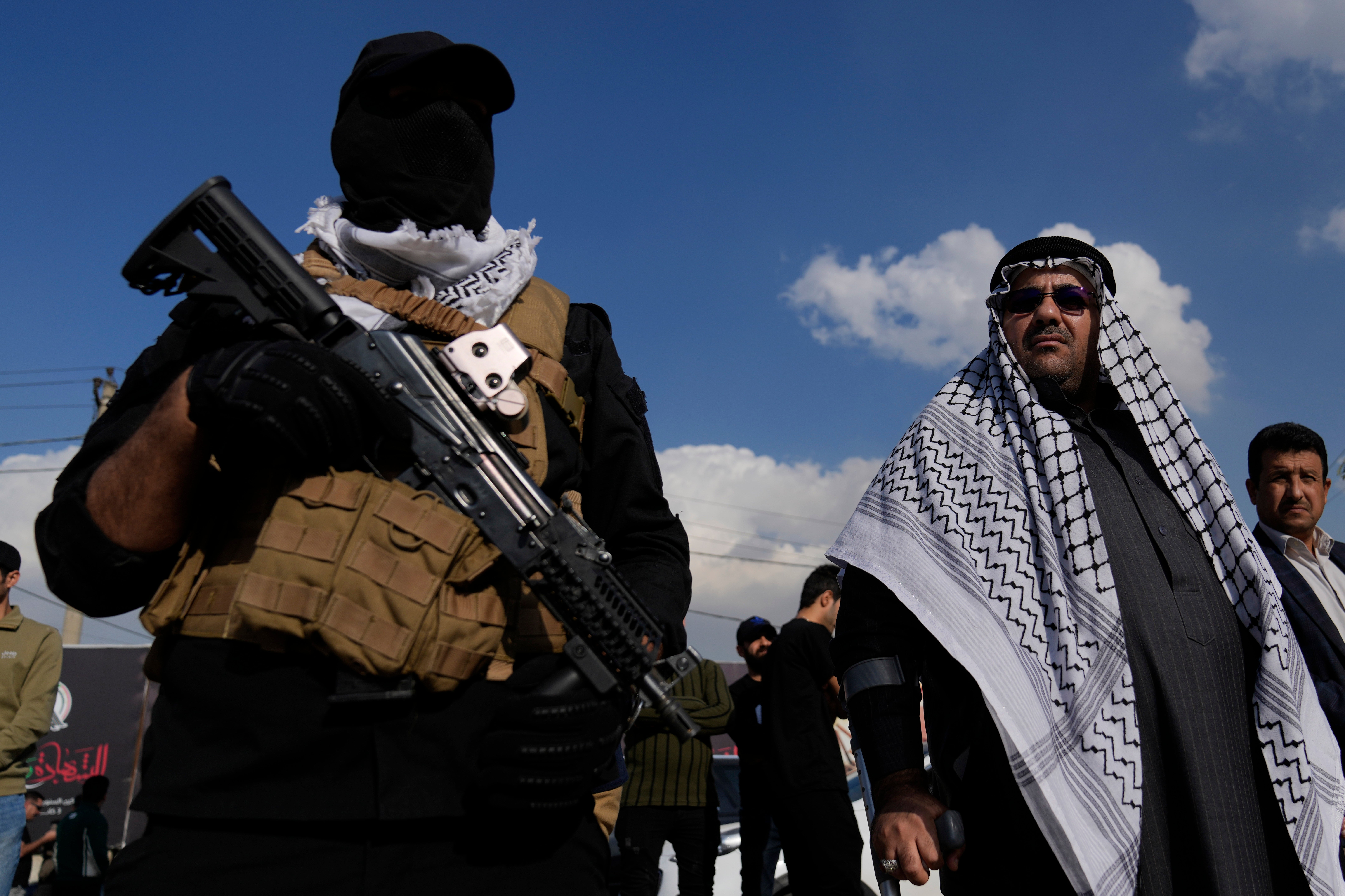 Members of an Iraqi Shiite militant group attend the funeral of a fighter with the Kataib Hezbollah, who was killed in a US airstrike