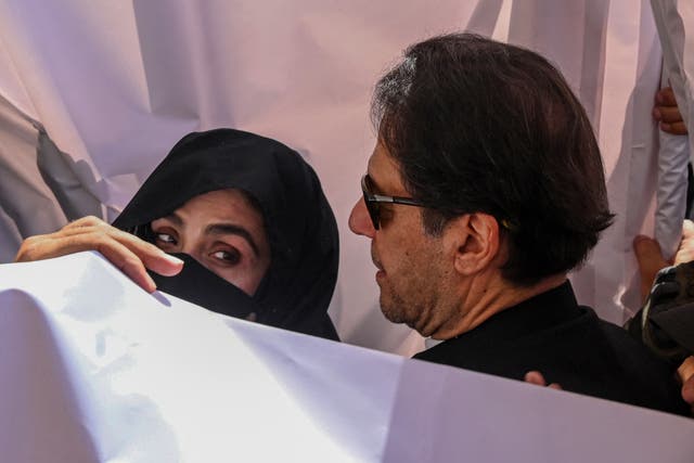 <p>Former Pakistan Prime Minister Imran Khan (C) with his wife Bushra Bibi (L) arrive to appear at a high court in Lahore </p>