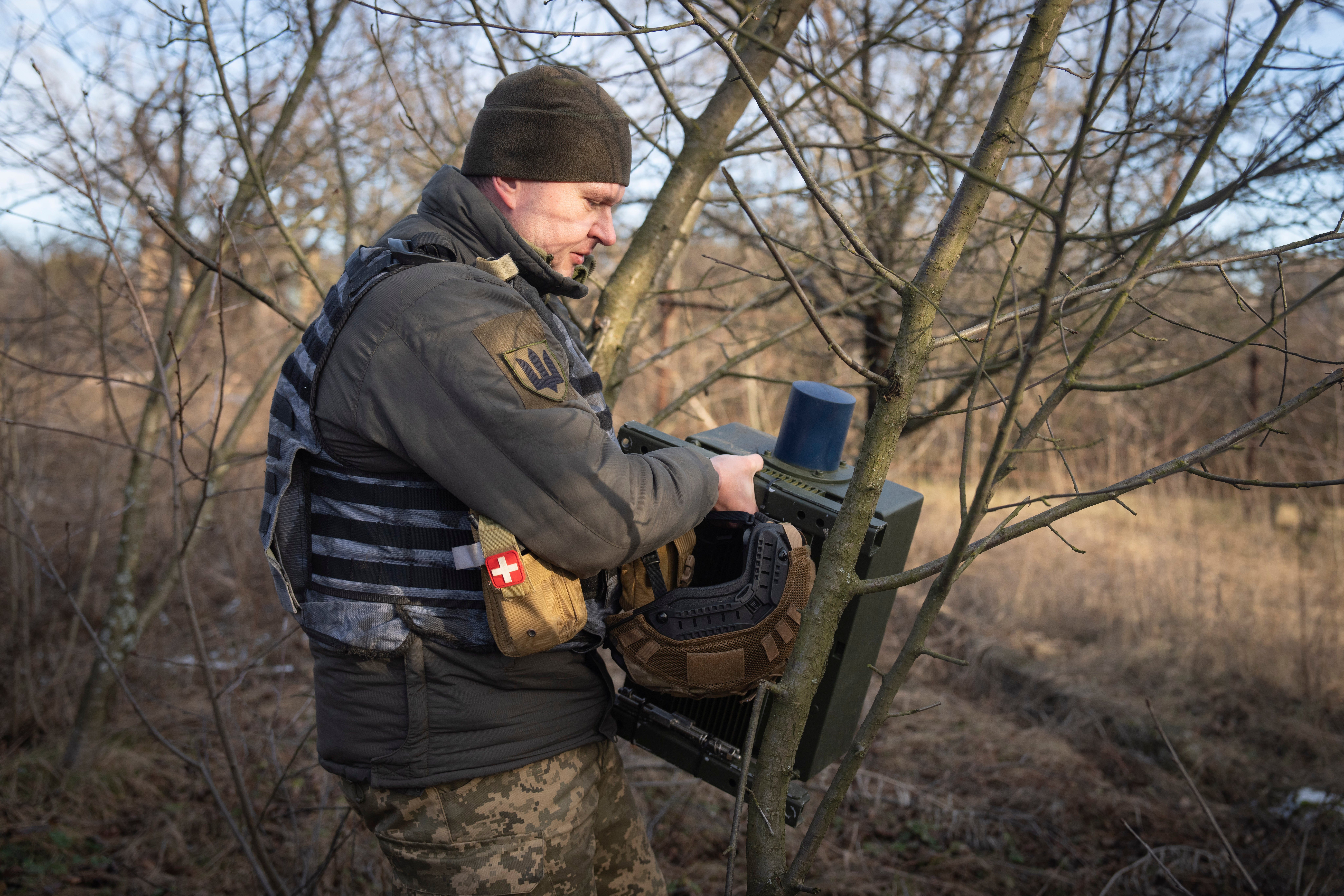 A Ukrainian serviceman installs an electronic warfare system to quell Russian drones at the front line, near Bakhmut