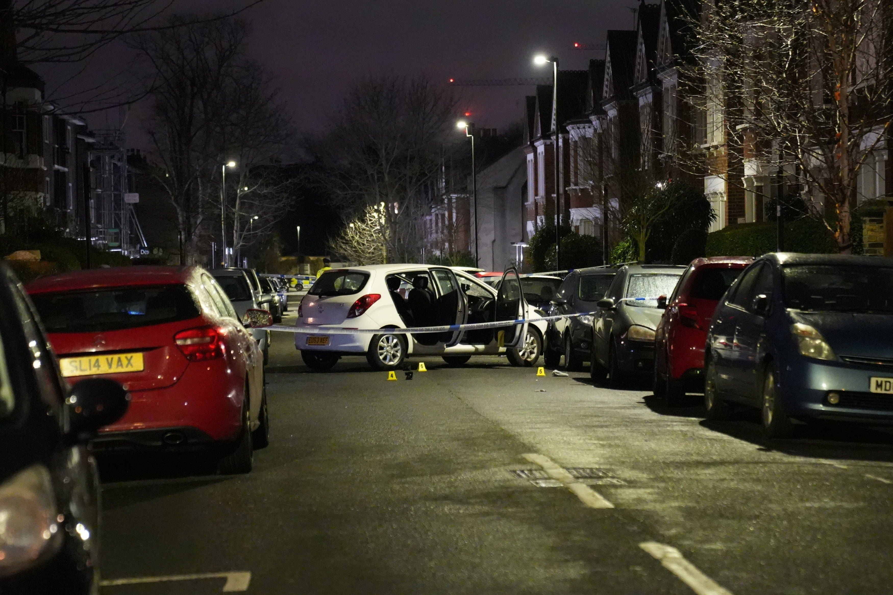 Police at the scene of an incident near Clapham Common, south London, after a suspected corrosive substance was thrown at a woman and her two young children