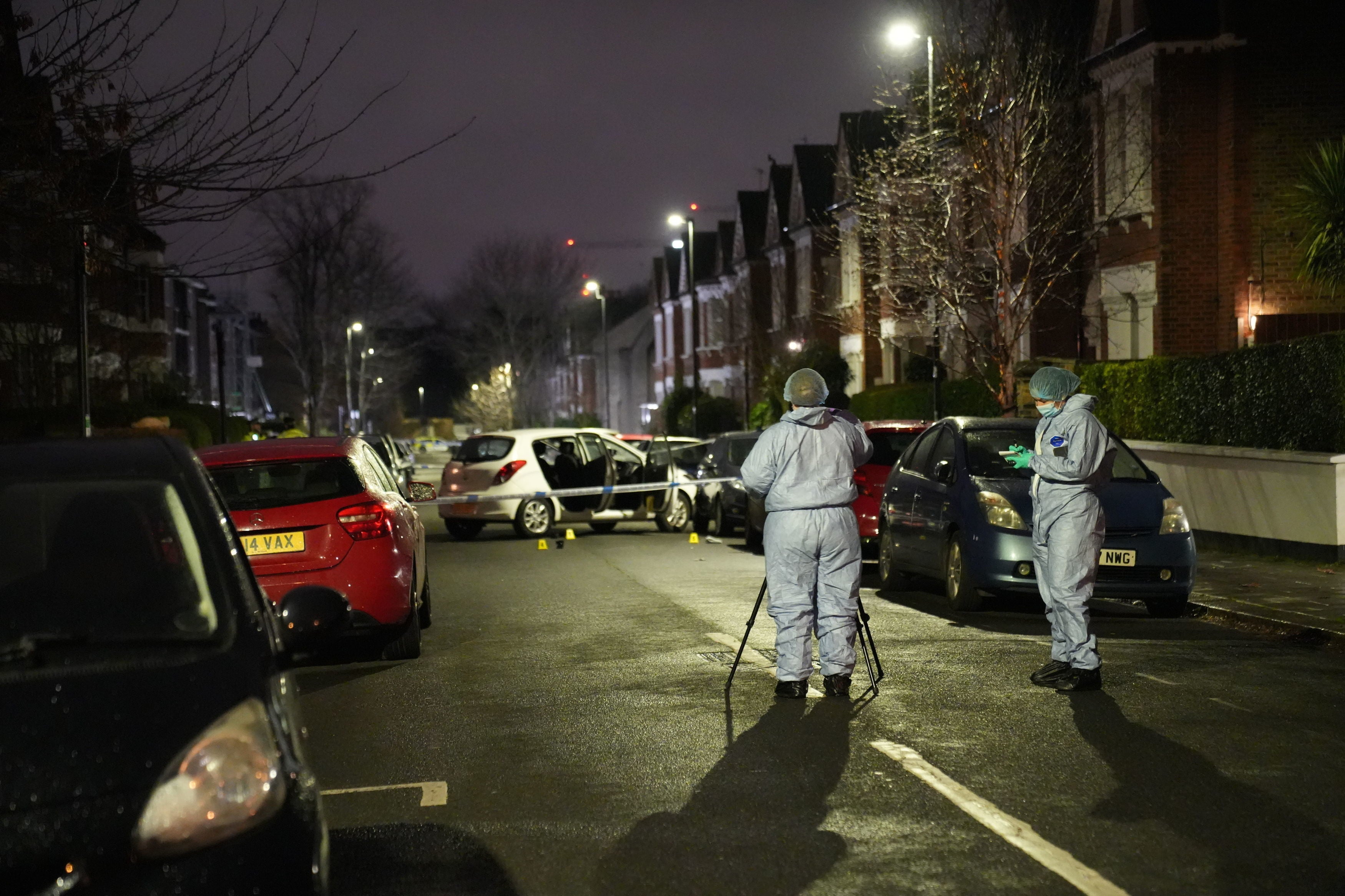 Police at the scene of an incident near Clapham Common, south London, after a suspected corrosive substance was thrown at a woman and her two young children