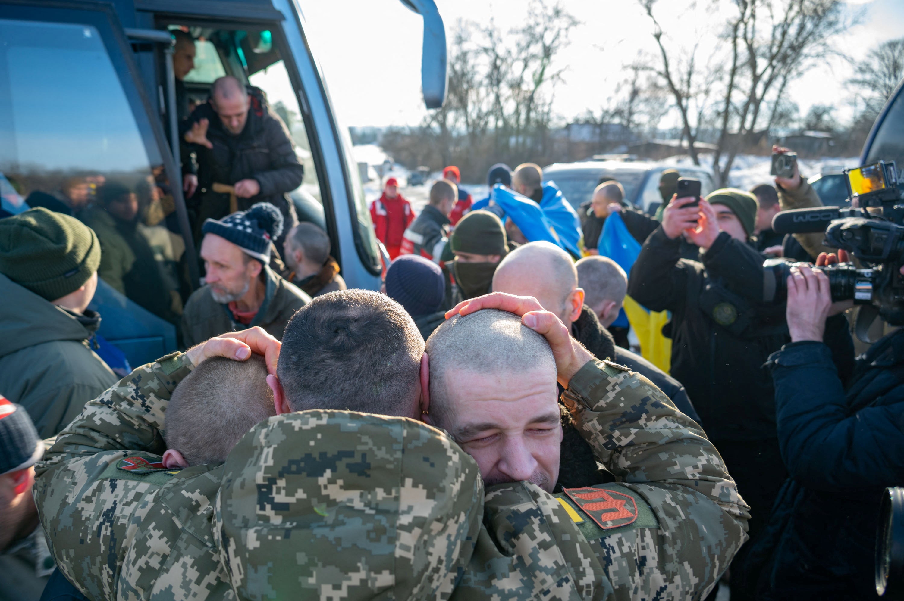A Ukrainian serviceman embraces prisoners of war (POWs) after a swap, amid Russia’s attack on Ukraine, at an unknown location in Ukraine
