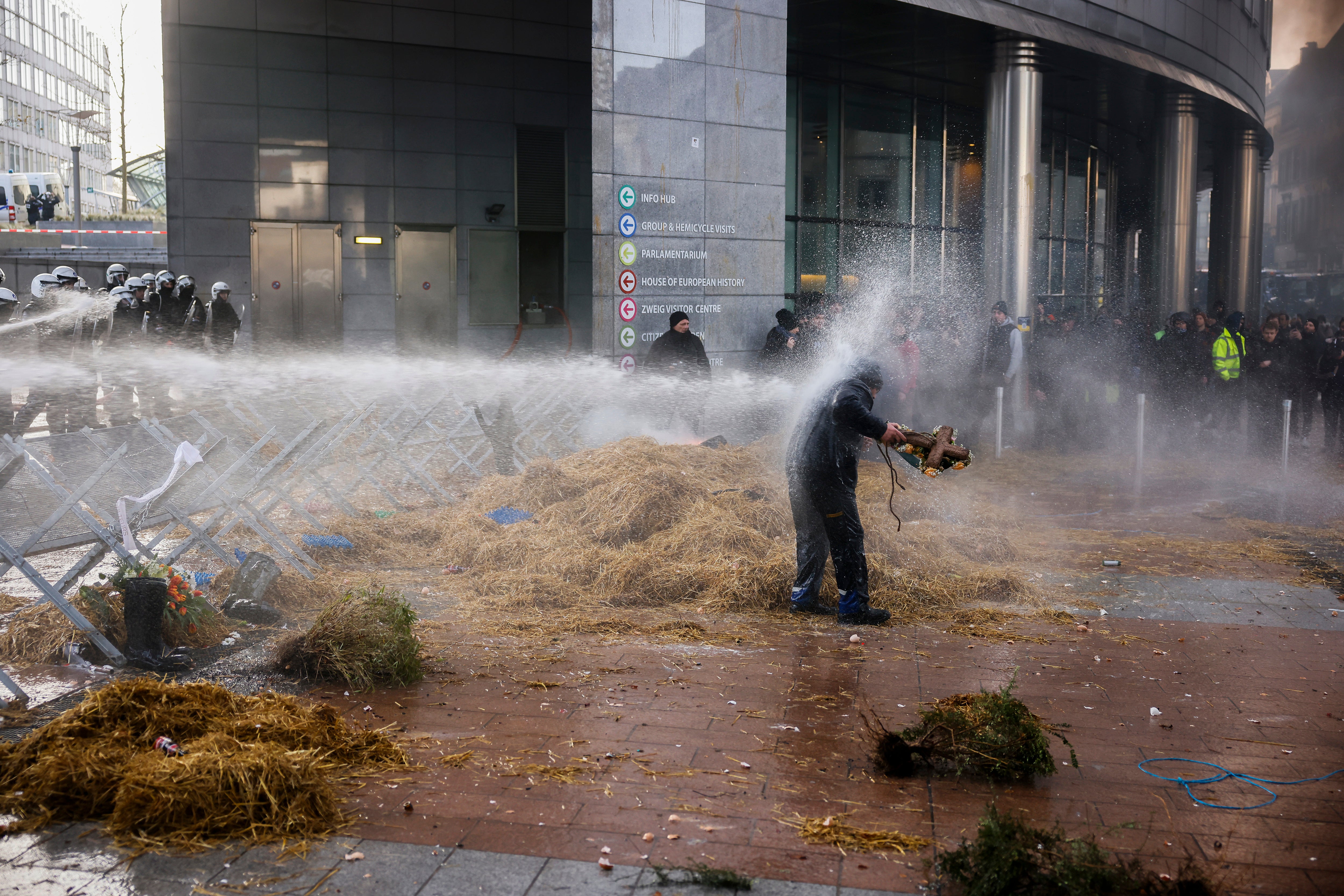 Anti-riot police use water to disperse people during a protest by farmers outside the European parliament in Brussels