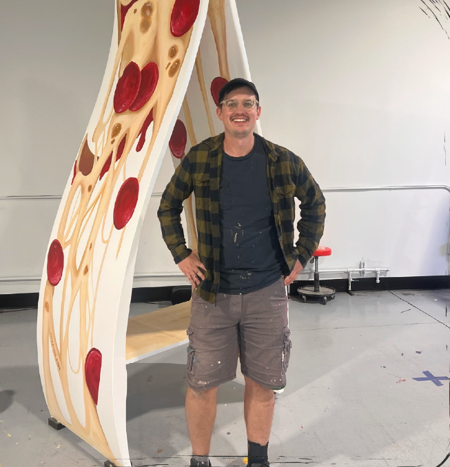 Mike Sobeck, a Cleveland based artist, who has specialized in the art of pizza painting and does murals all over the greater Cleveland area, with his ‘pizza-slice’ bench