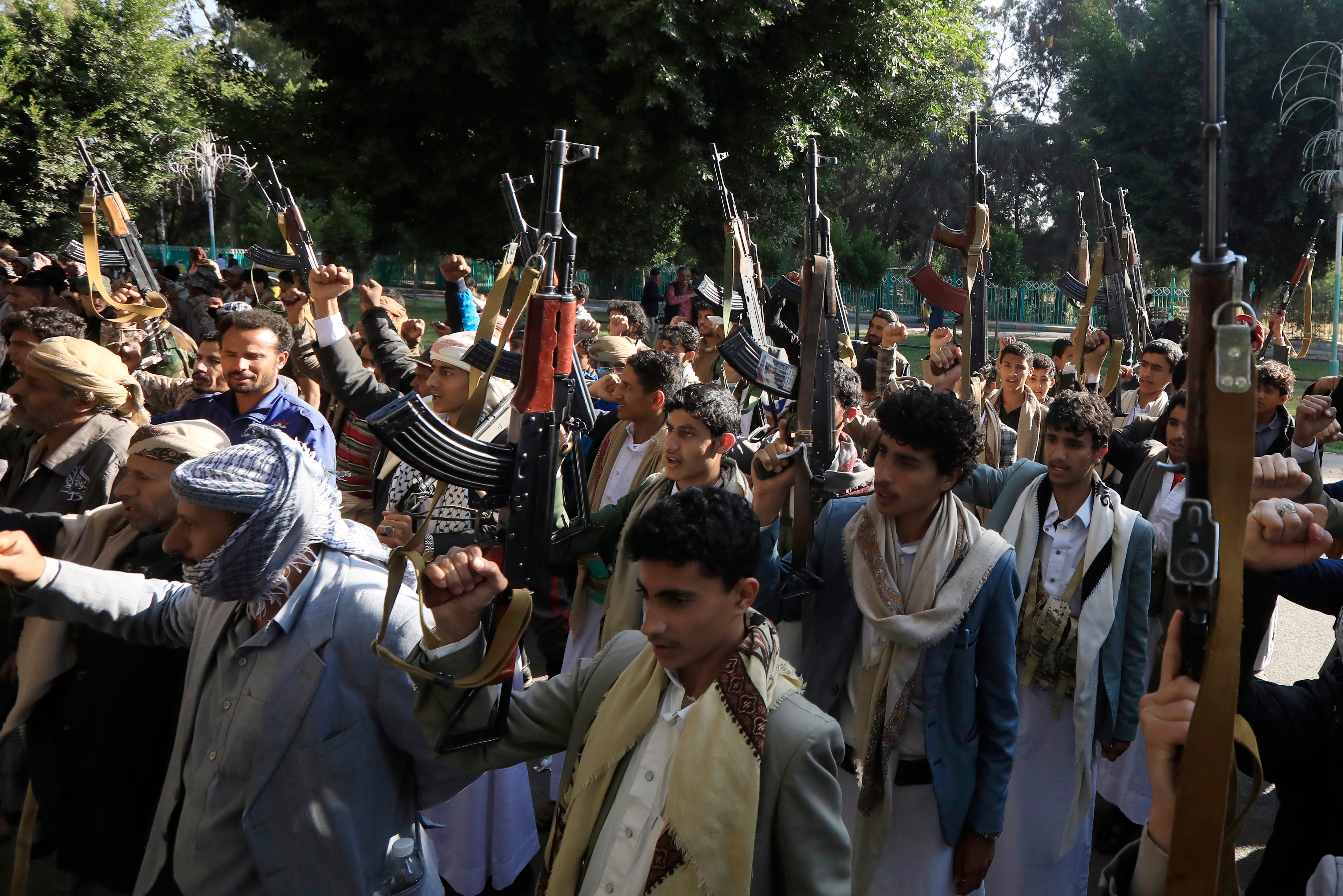 Newly-recruited Houthi fighters hold up weapons during a protest against the US-UK air strikes, in Sana’a, Yemen