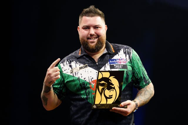 Michael Smith celebrates with his trophy after winning on the first night of the 2024 Premier League season (David Davies/PA)