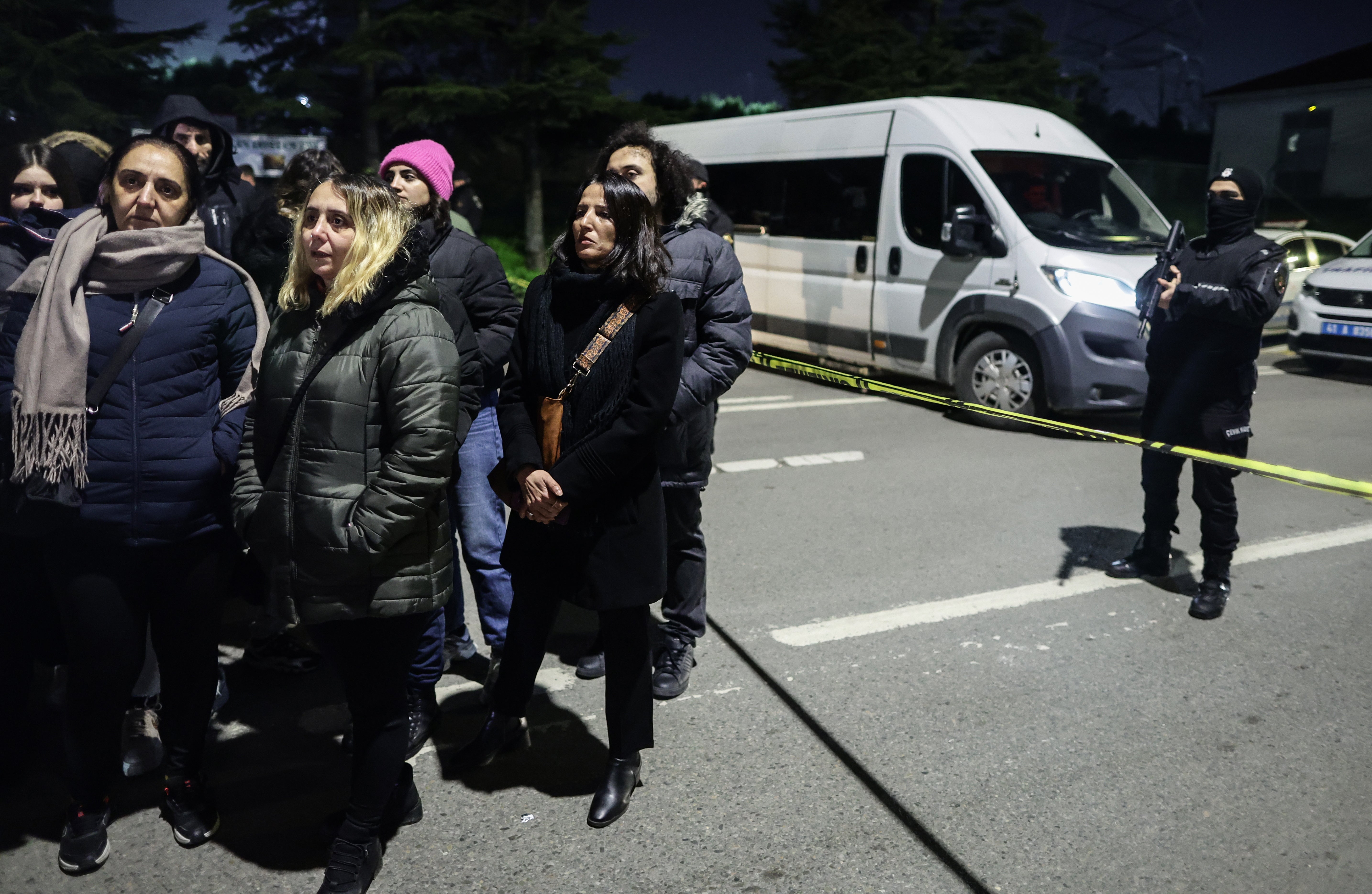 Relatives of hostages wait as Turkish police secure the area of the Procter & Gamble plant