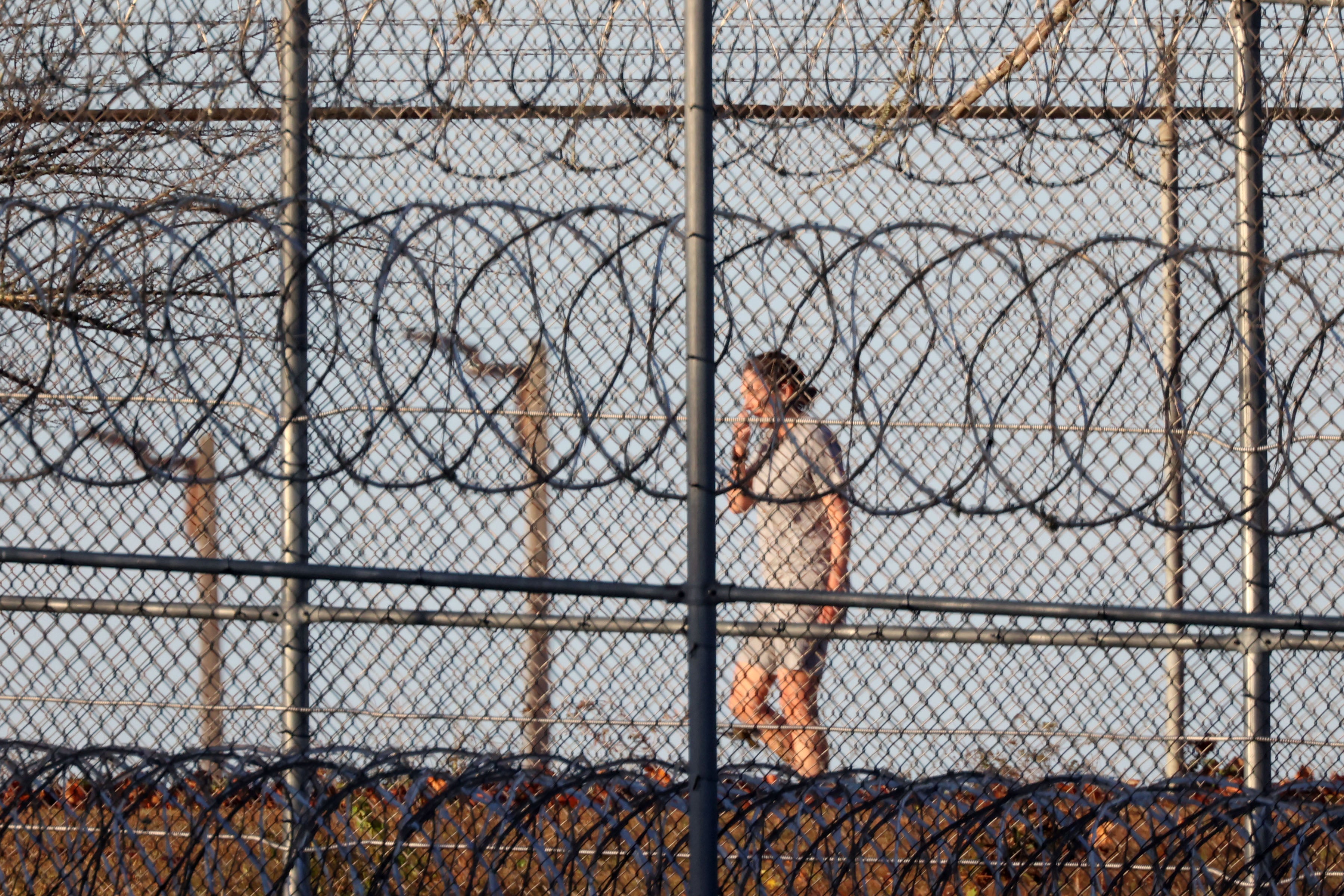 Maxwell behind a wired fence at FCI Tallahassee