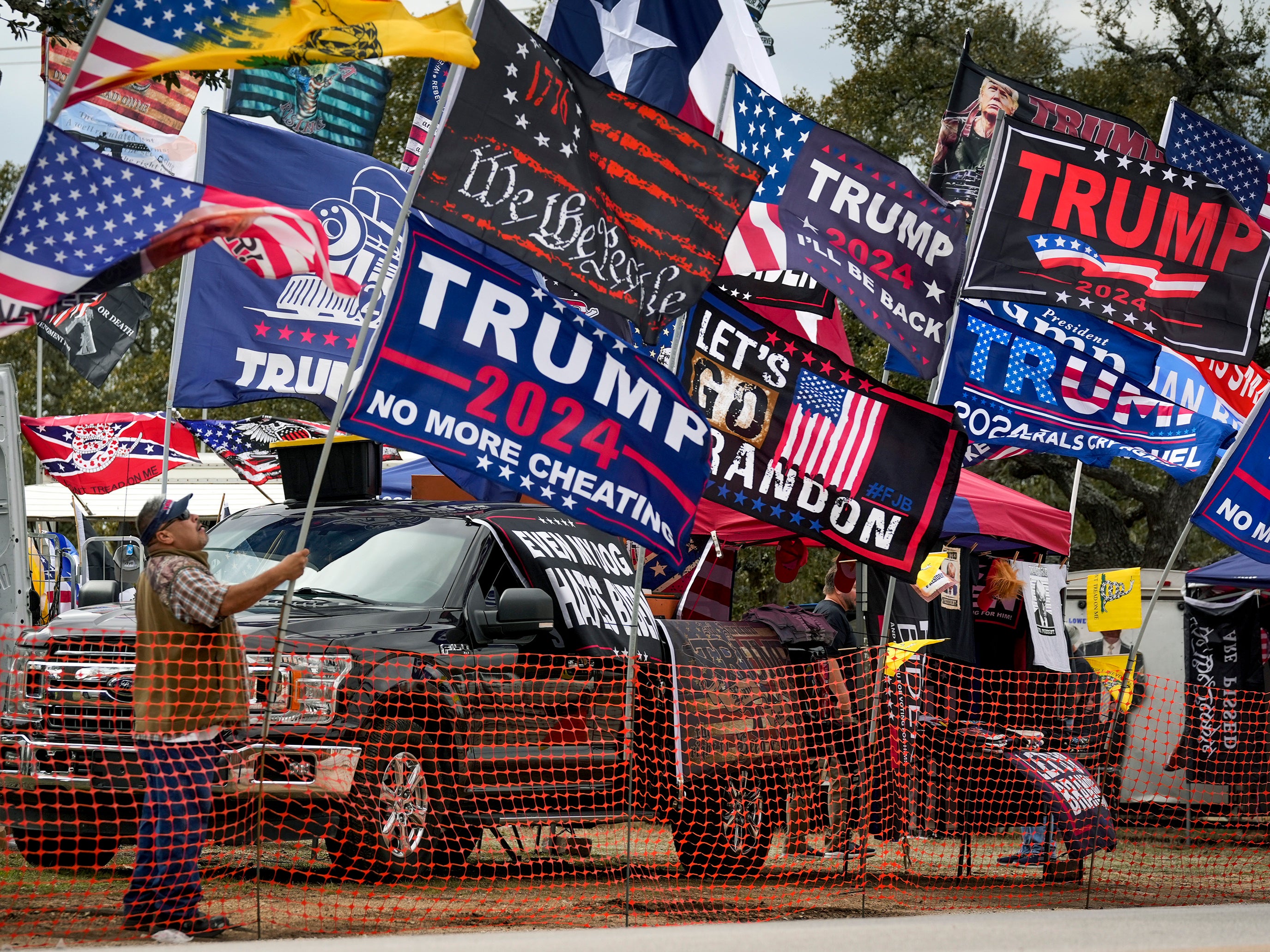 Rudy Martinez, of San Antonio, sets up his flags for sale at the Take Our Border Back Convoy in Dripping Springs, Texas, on Thursday