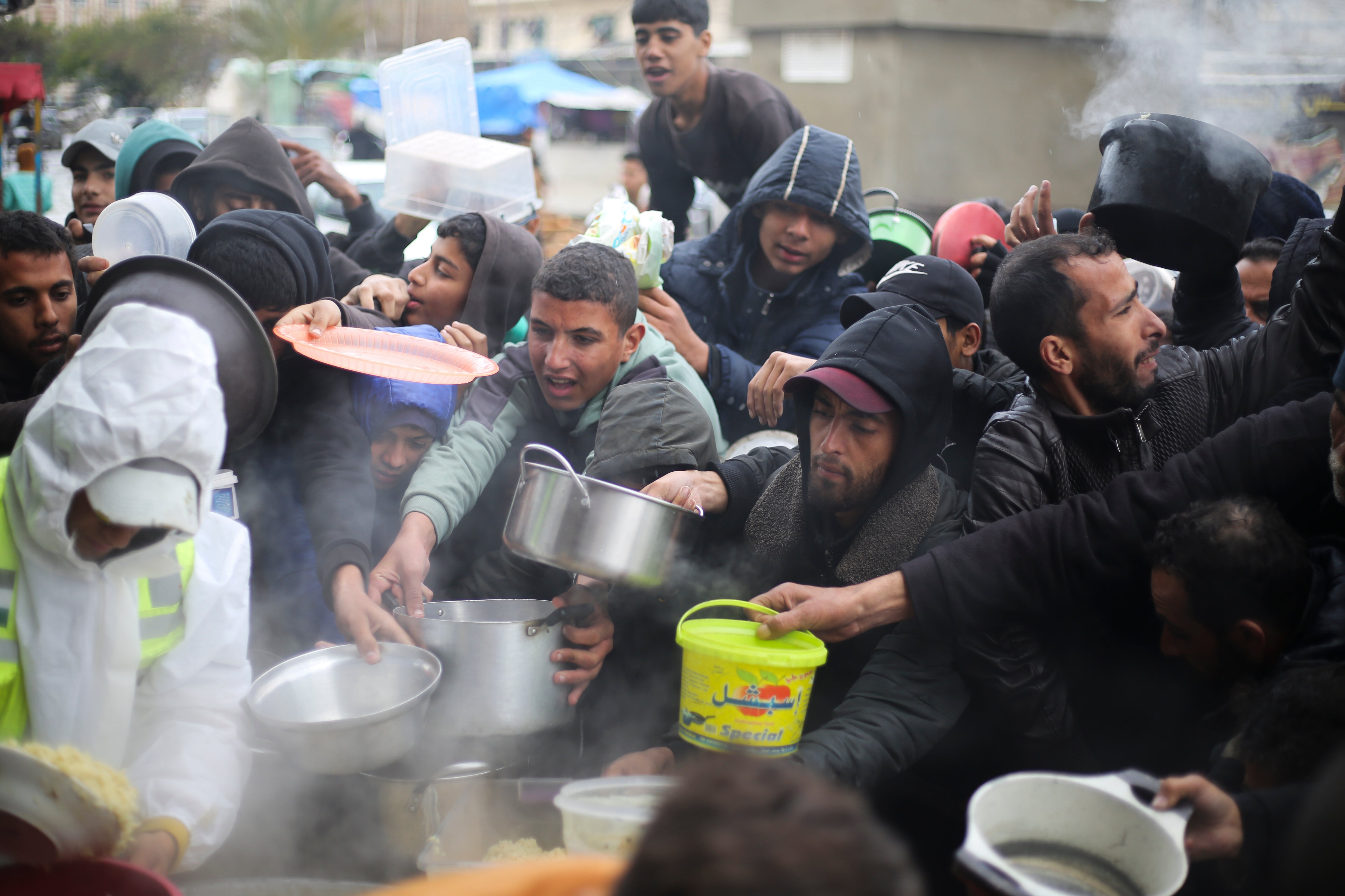 Palestinians line up for free food distribution during the ongoing Israeli air and ground offensive in Khan Younis, Gaza Strip