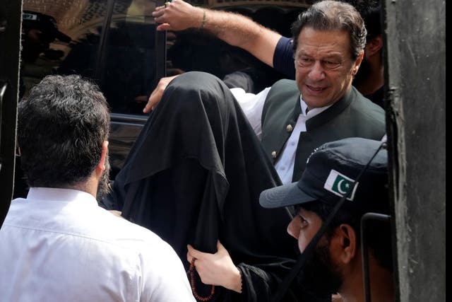<p>Imran Khan, right, with his wife, Bushra Bibi, arrive at court in Lahore last June </p>