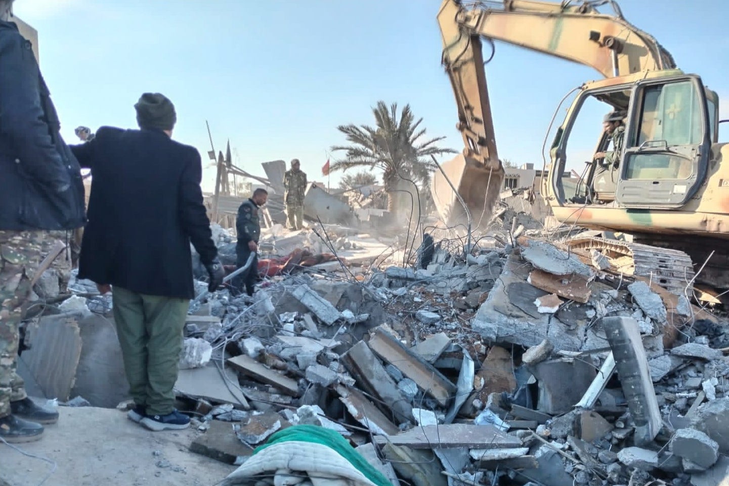 Members of the Iraqi Shiite Popular Mobilization Forces on Saturday clean the rubble after a US airstrike in al-Qaim