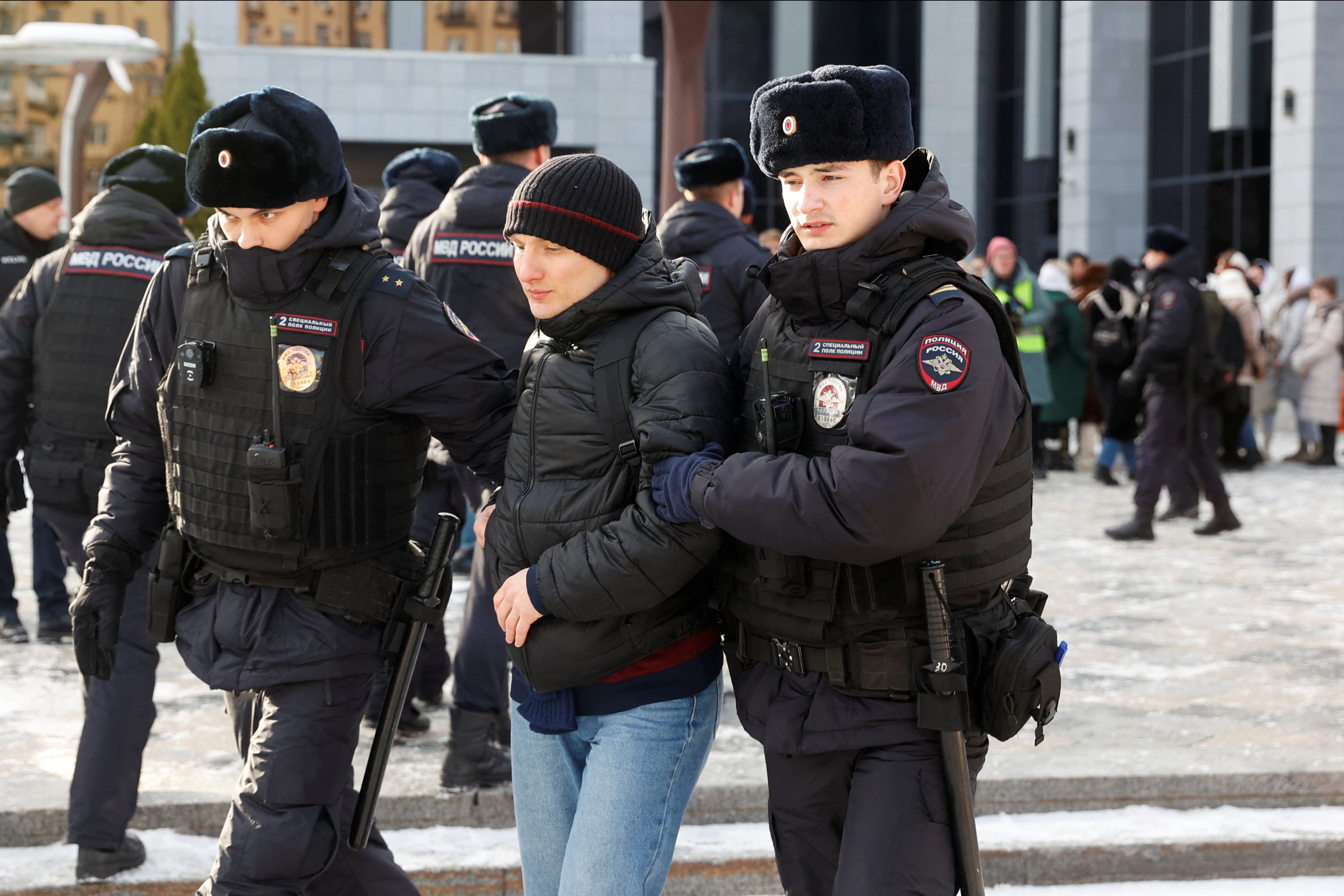 Police officers detain an individual as protests were held in Moscow on Saturday