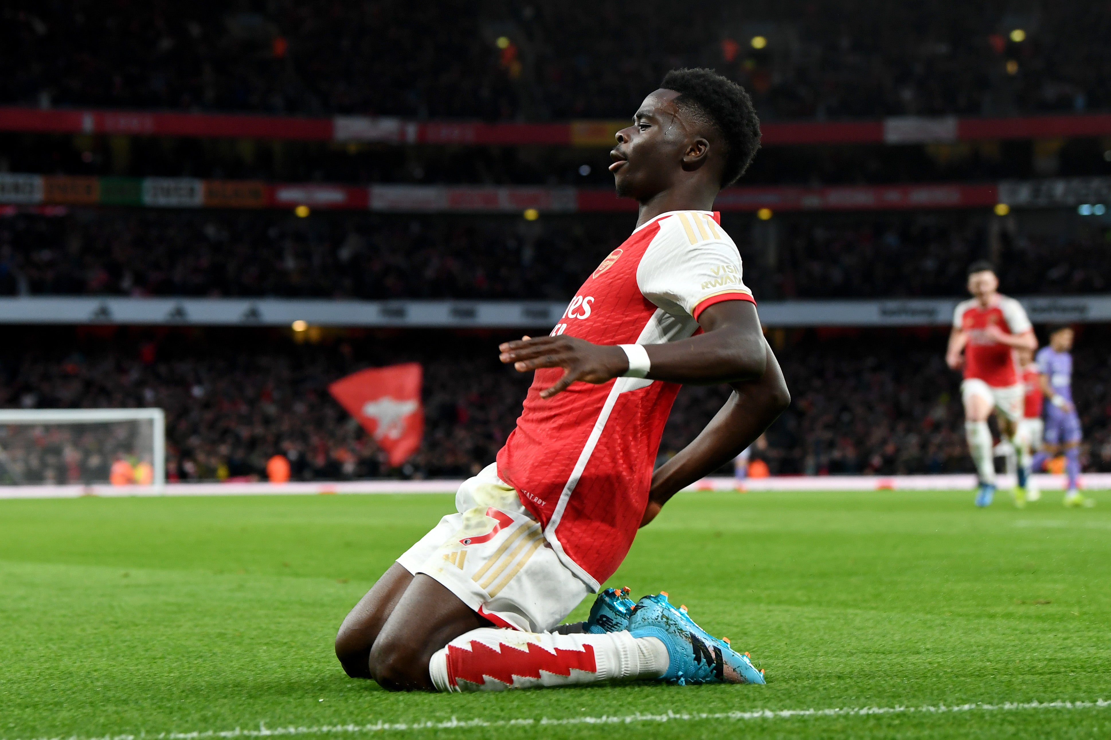 Bukayo Saka slides in celebration after scoring Arsenal’s opening goal