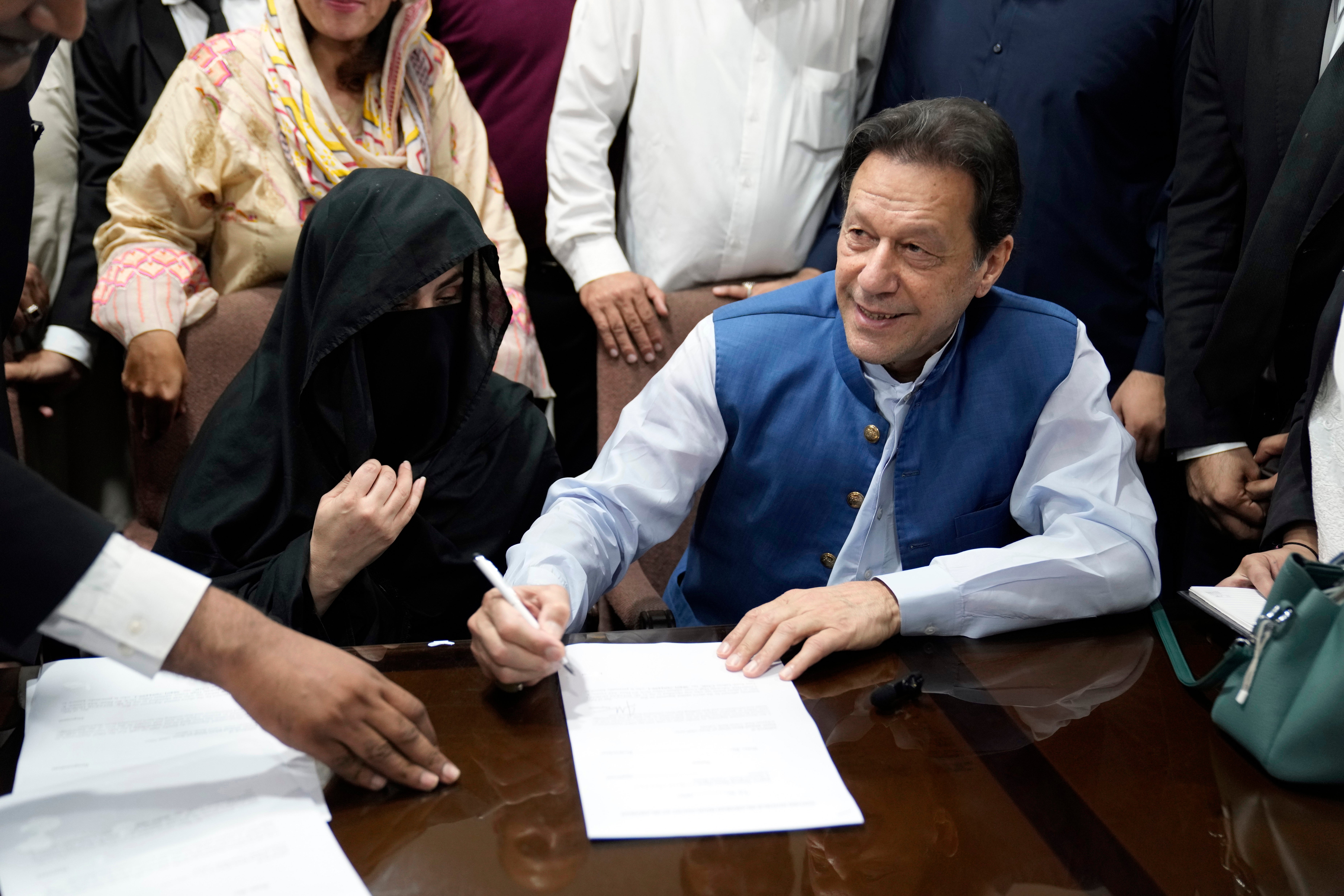 Imran Khan and his wife, Bushra Bibi, face the media in Lahore last July