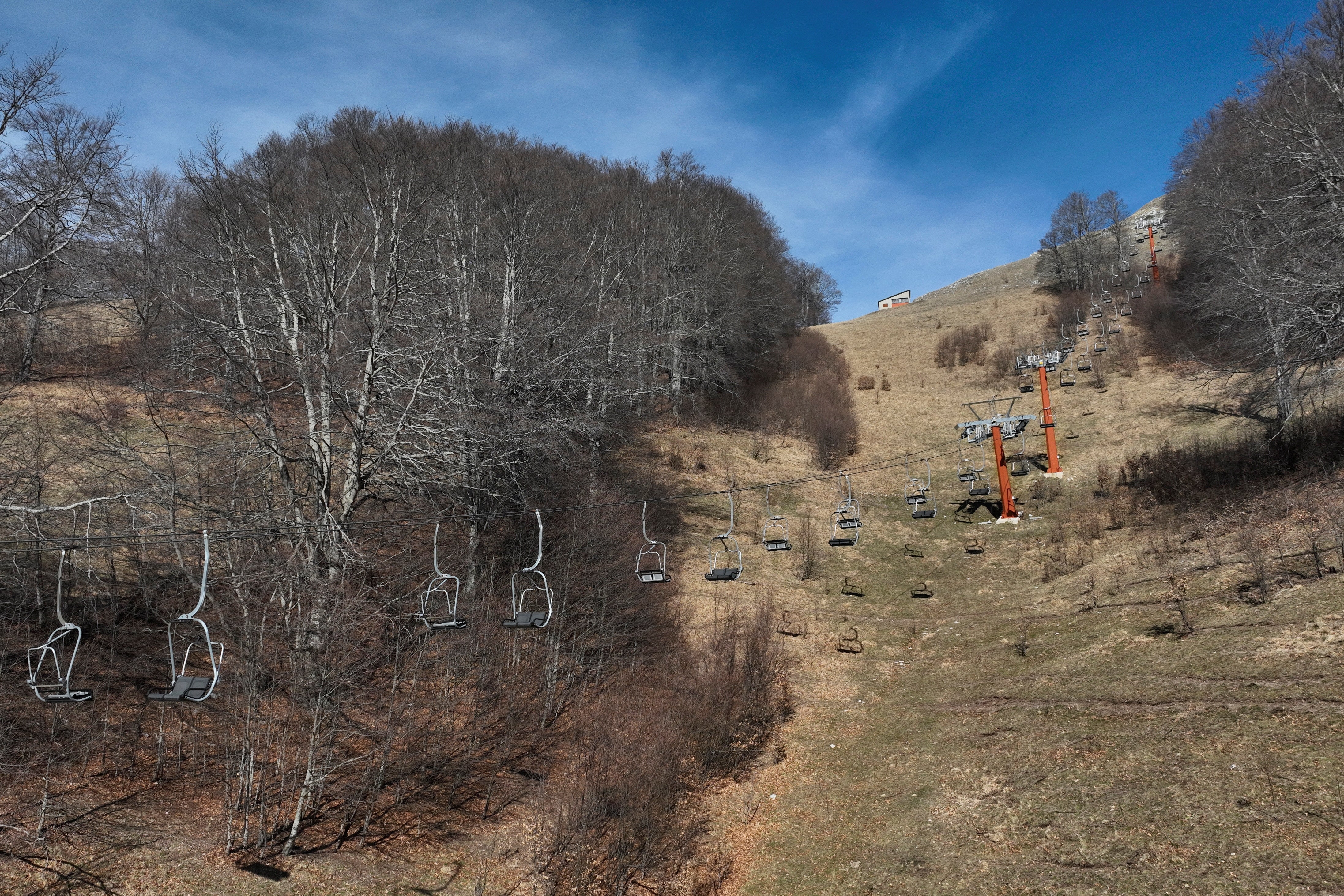 <p>A view of a closed chair-lift at a ski slope without snow as Mount Terminillo</p>