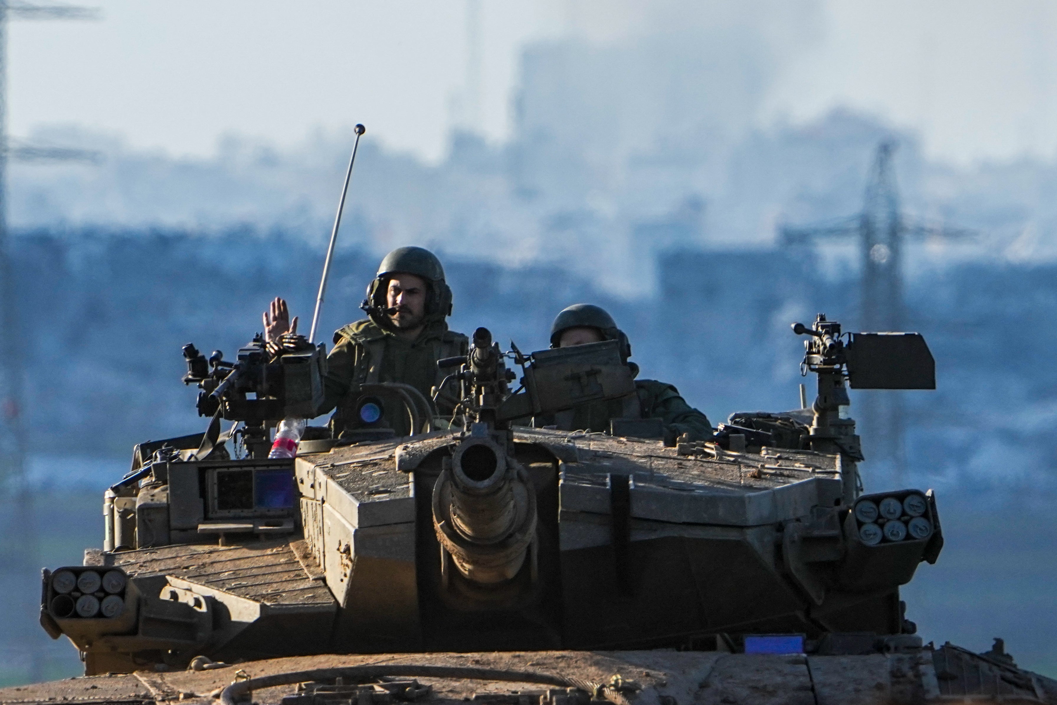 Israeli soldiers drive a tank on the border with the Gaza Strip