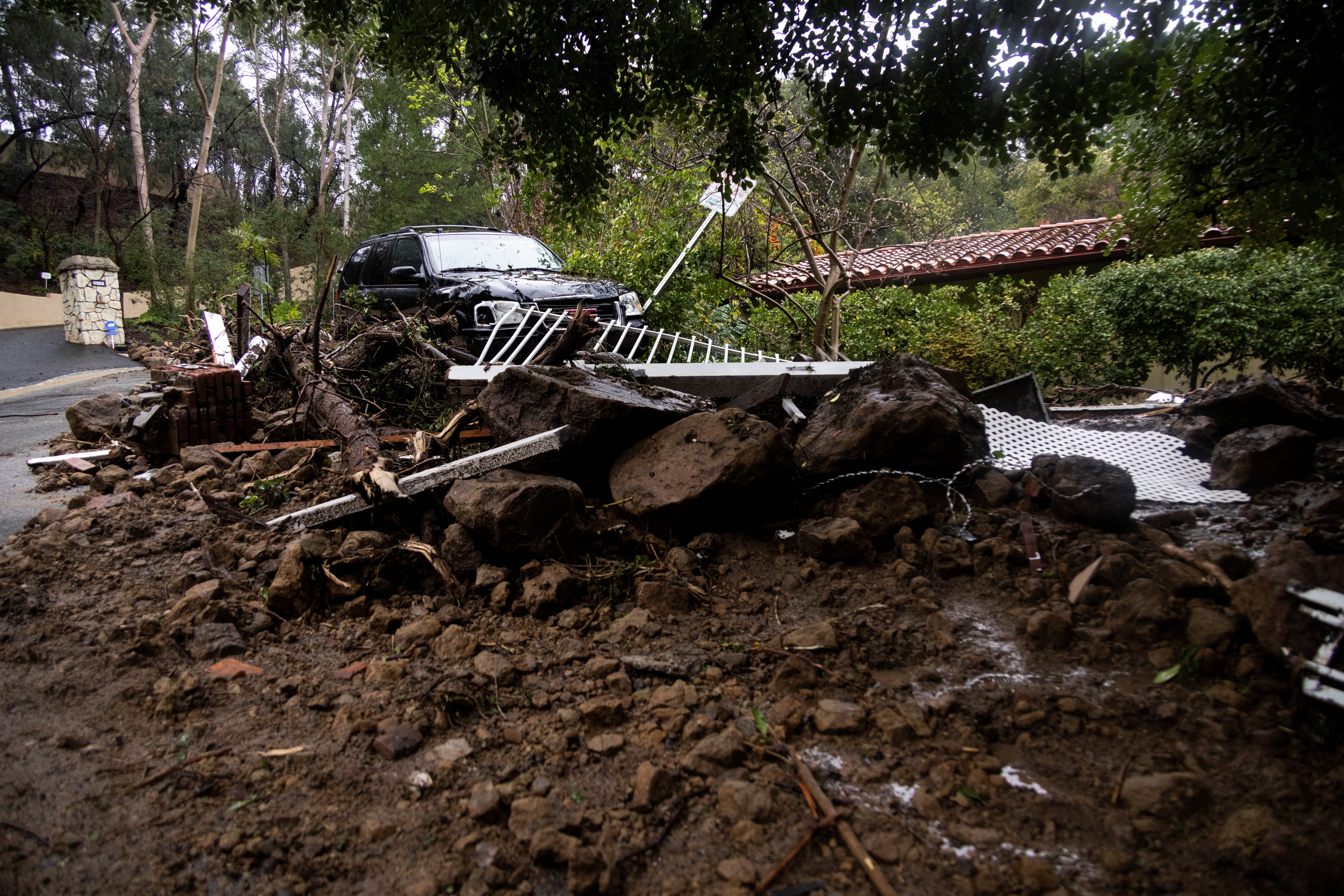 A car sits on top of a pile of debris during a rain storm in Studio City, California