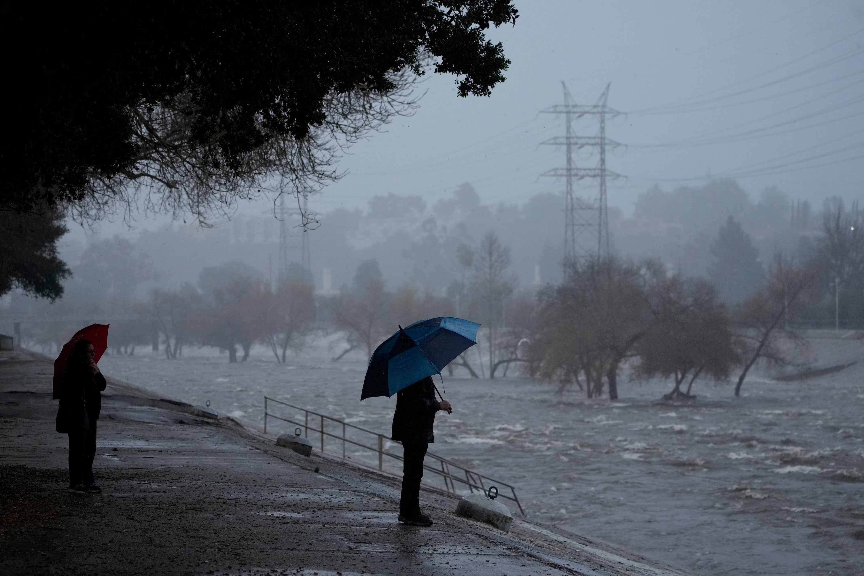 Two people observe heavy flooding and rain in California
