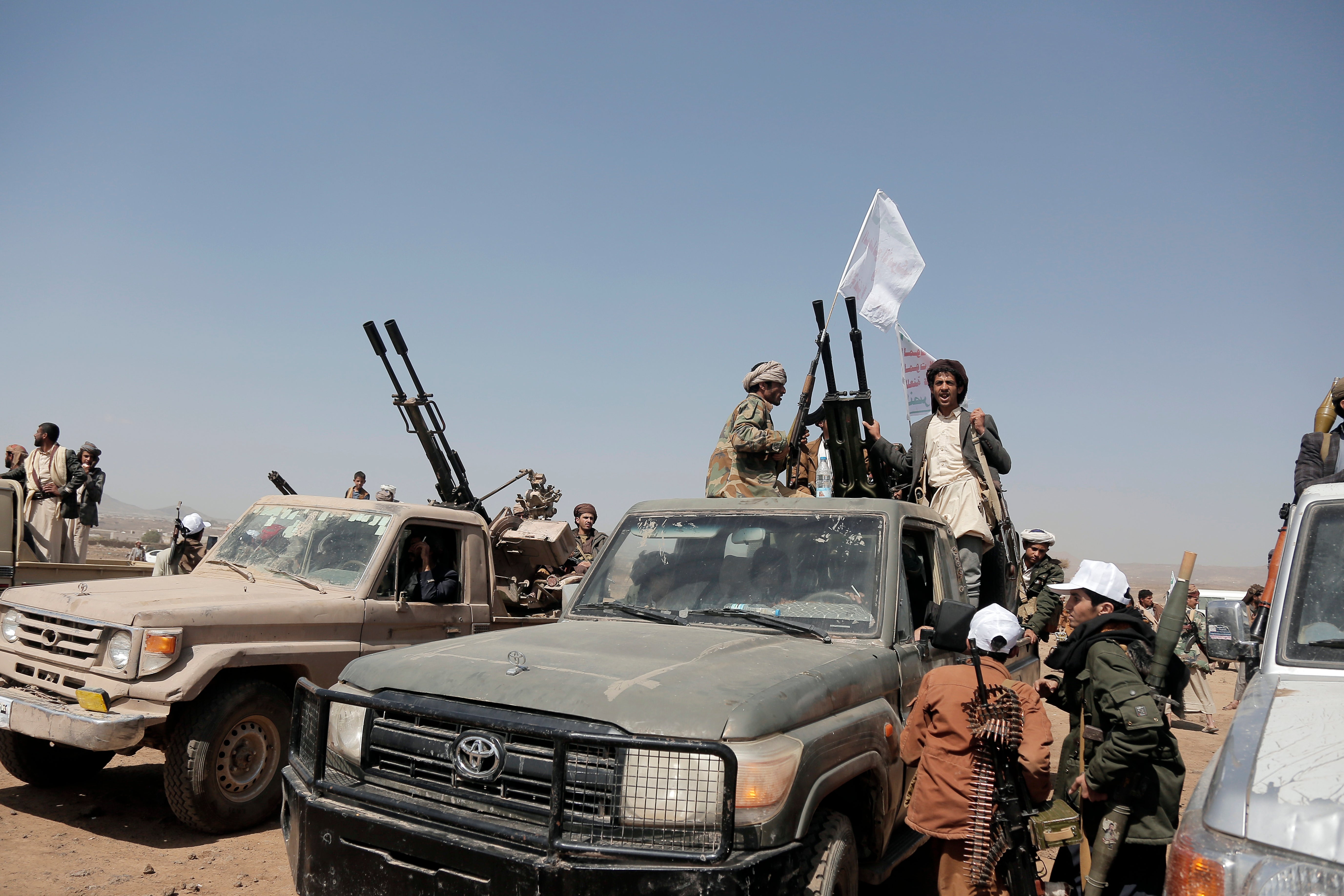 Houthi fighters man heavy machine guns mounted on vehicles at a rally in support of Palestinians in the Gaza