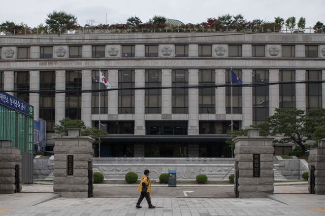 <p>A man walking past the Constitutional Court in Seoul</p>