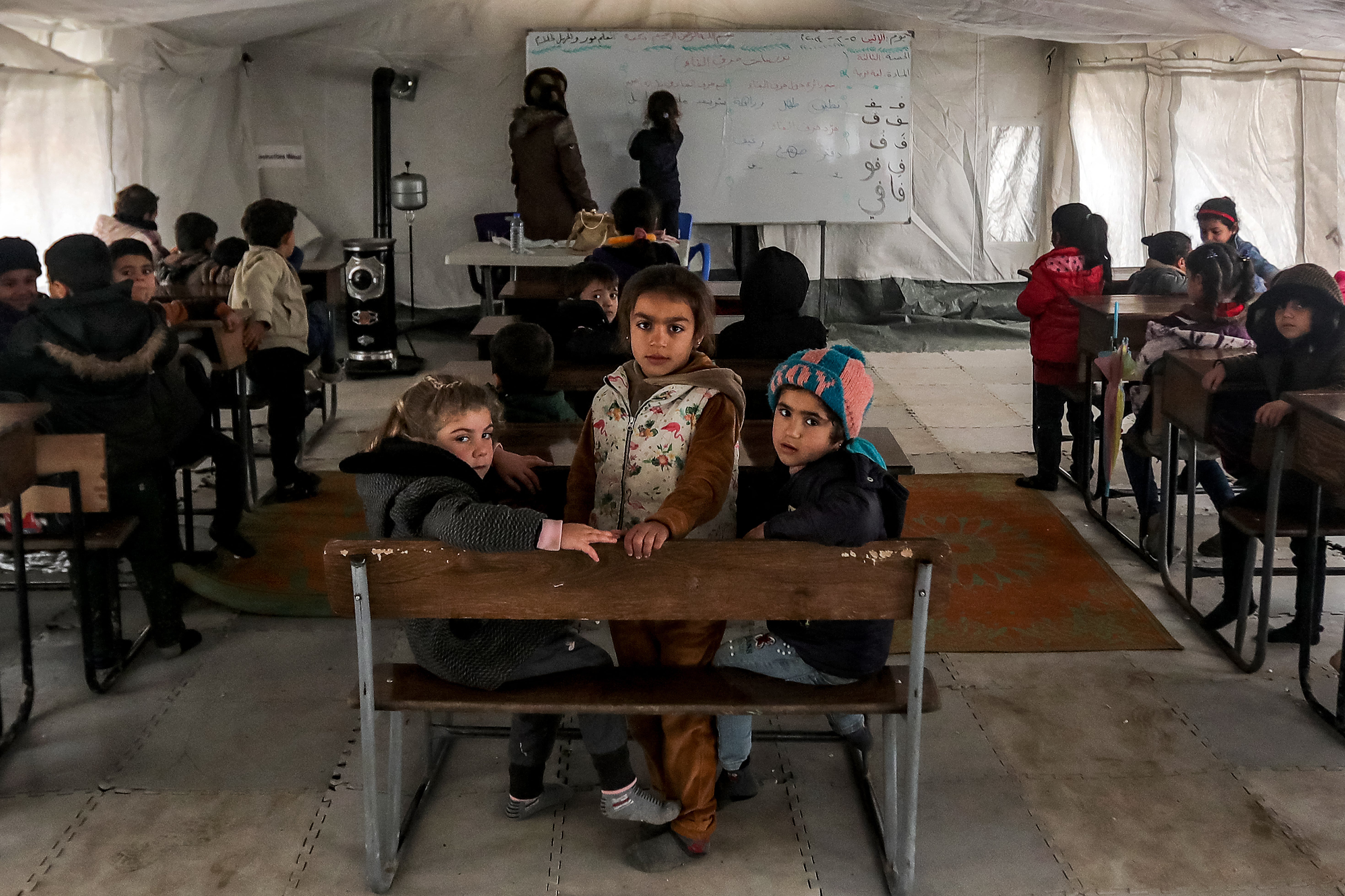 Children sit at a tent used as a makeshift school classroom in the town of Jindayris in the northwest of Syria’s Aleppo province