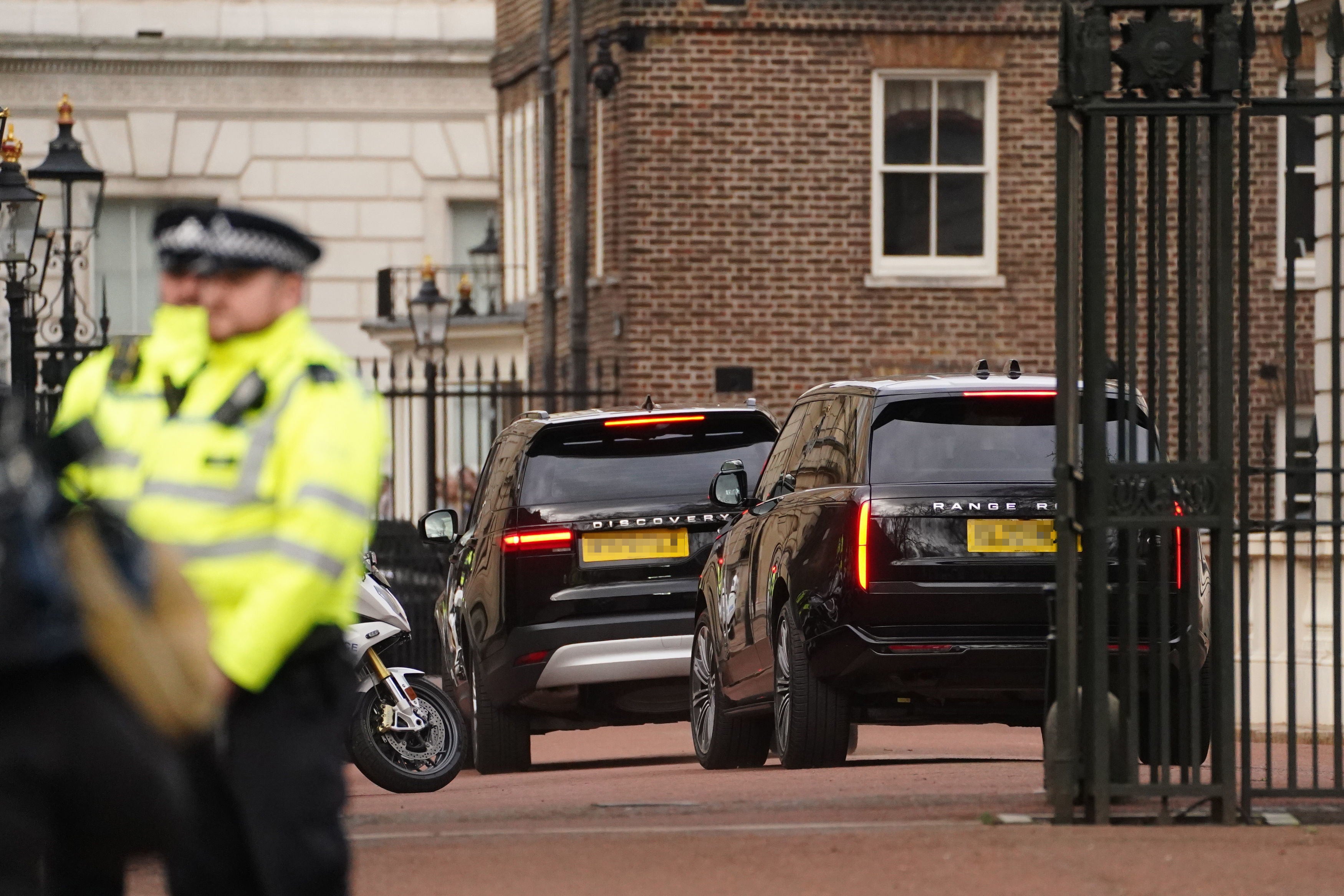 Two black SUVs, one believed to be carrying Prince Harry, arrive at Clarence House