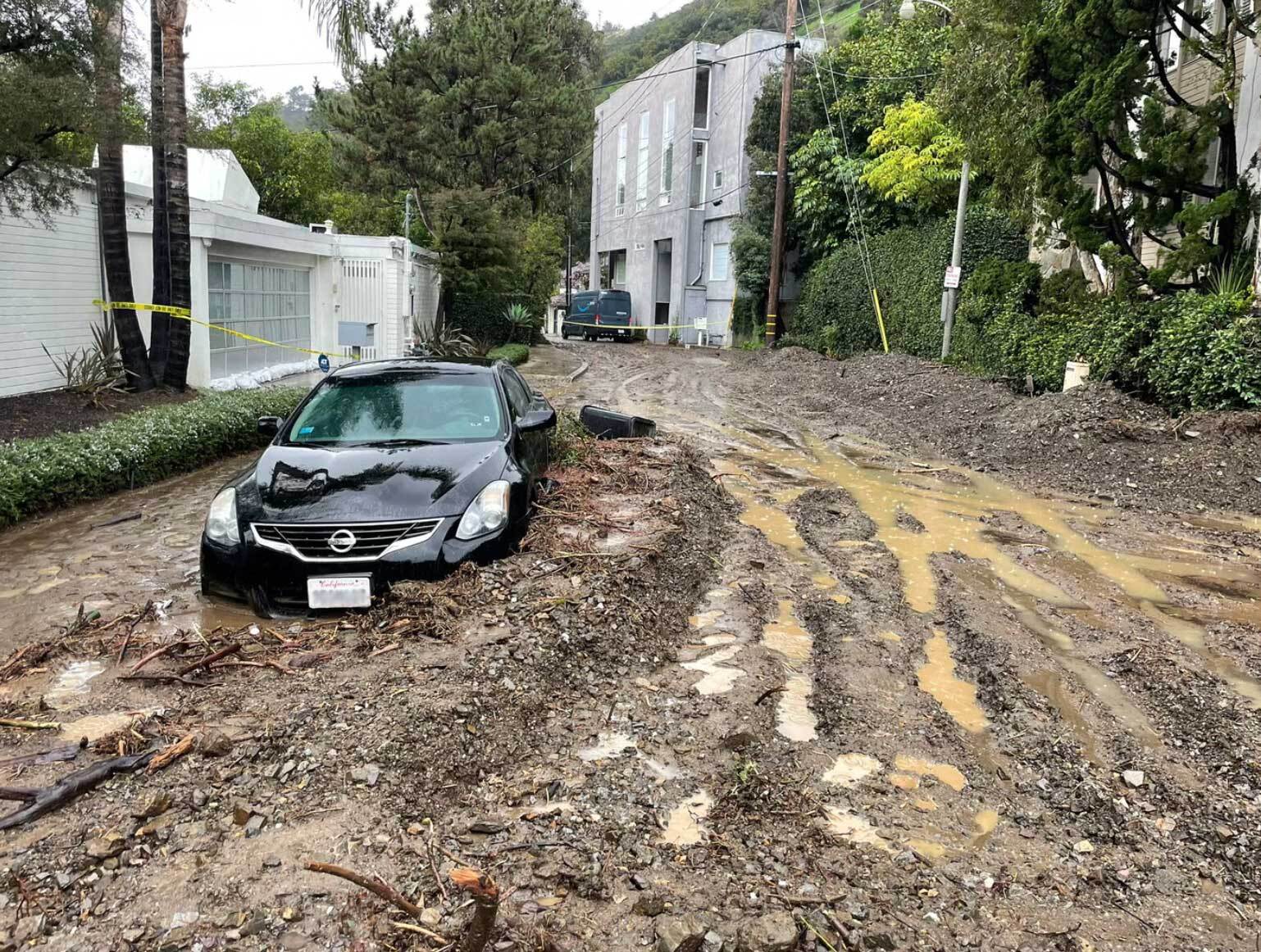 A car is half submerged in mud in the Beverly Crest neighbourhood of Los Angeles
