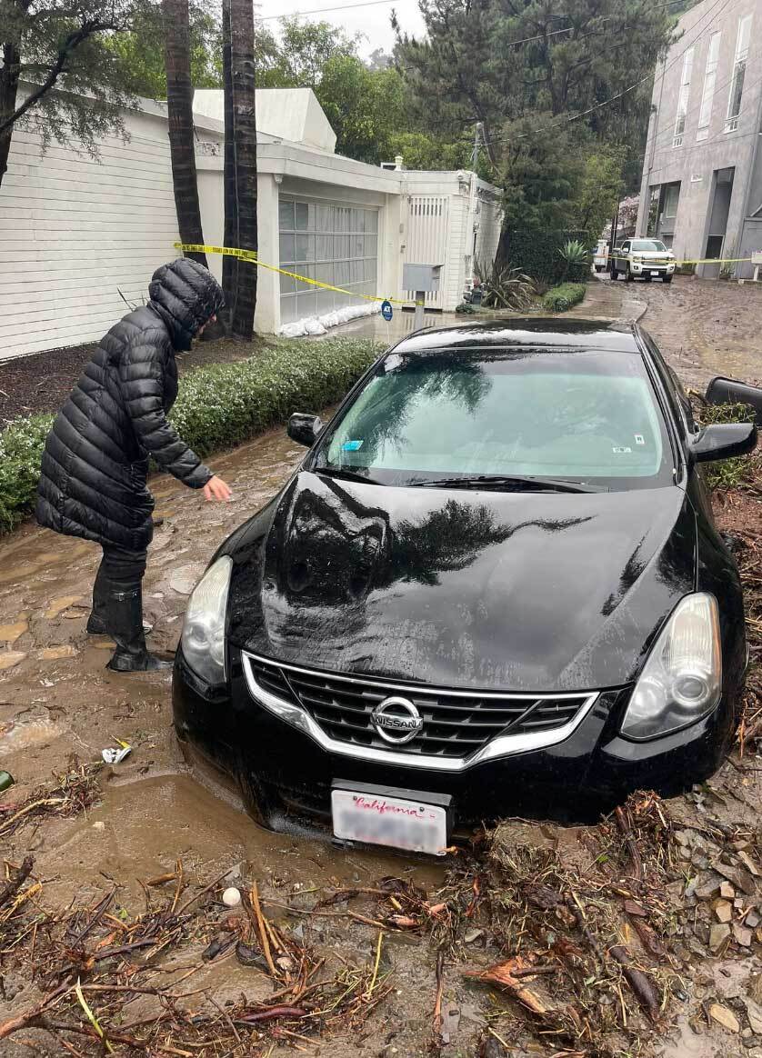 A black Nissan half submerged in mud was abandoned at the scene of the mudlside in Beverly Crest