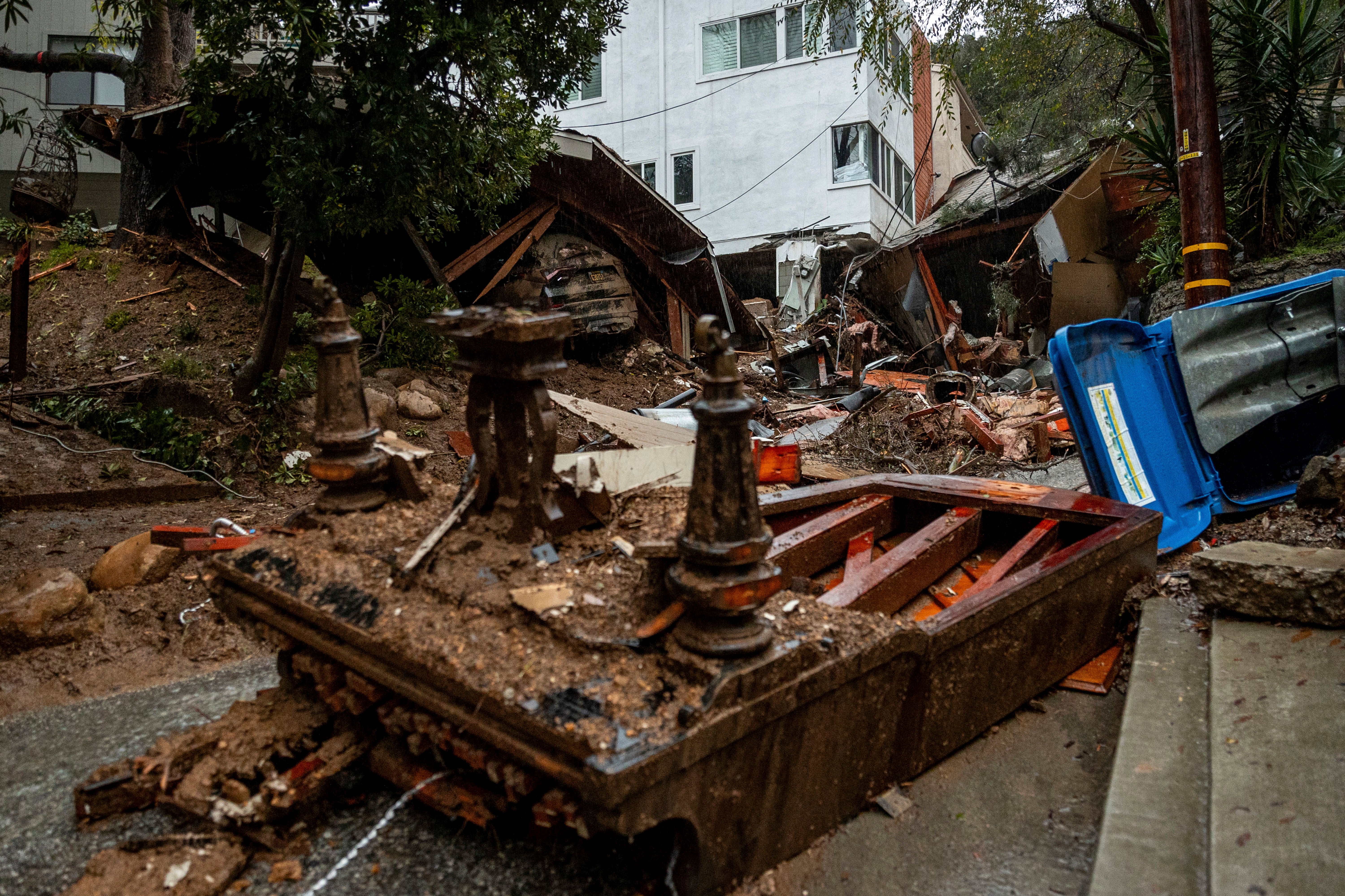 A grand piano lays upside down at a property destroyed by a mudslide during a storm, Tuesday, Feb. 6, 2024, in the Beverly Glen area of Los Angeles