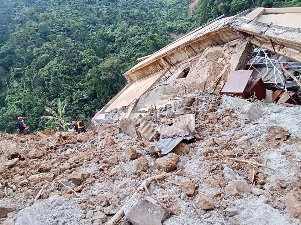 A handout photo provided by the Bureau of Fire Protection (BFP) shows rescuers working as they continue a search operation at a landslide-hit village in the town of Maco