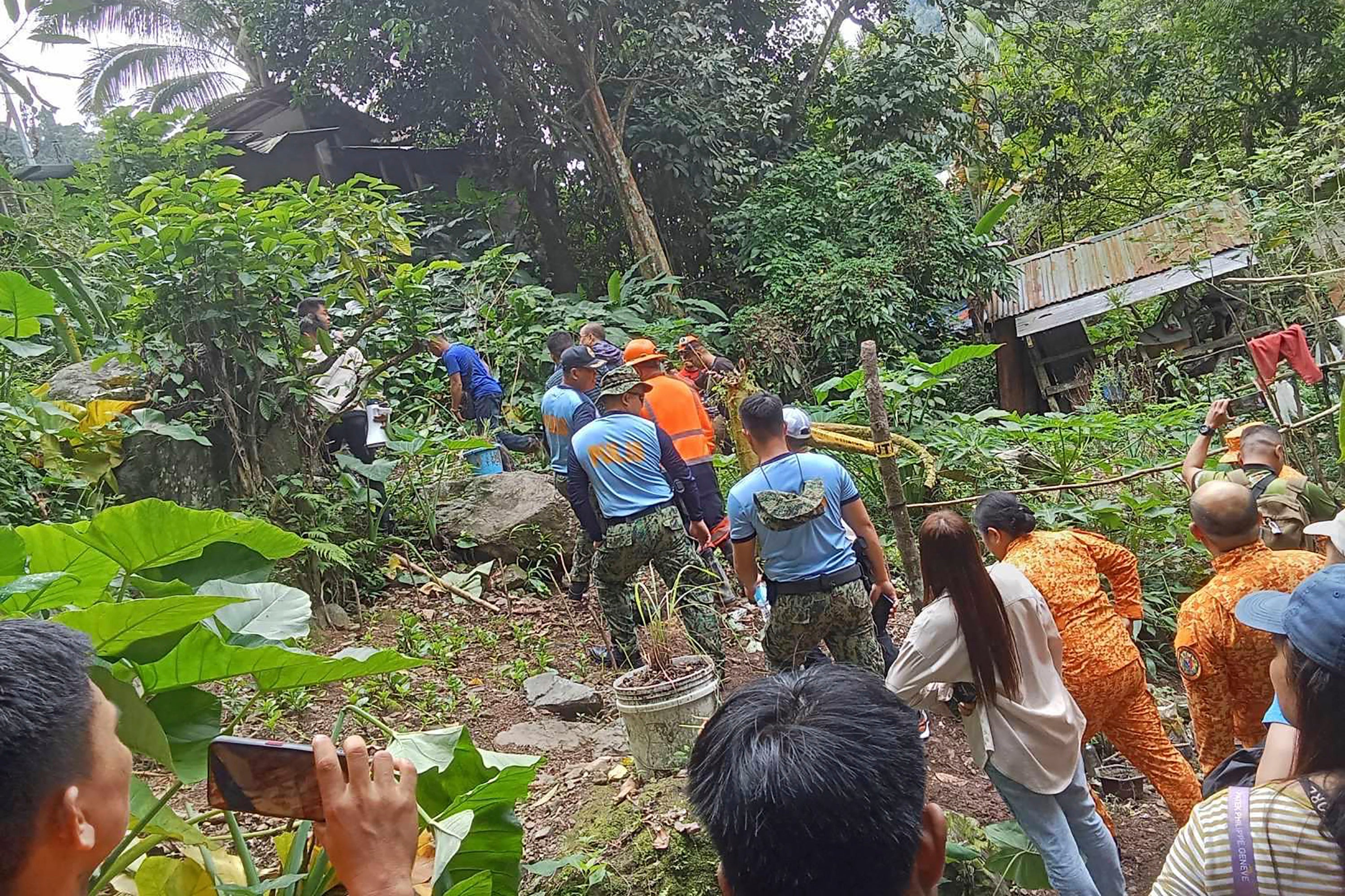 Responders conduct rescue operations at the site of a landslide
