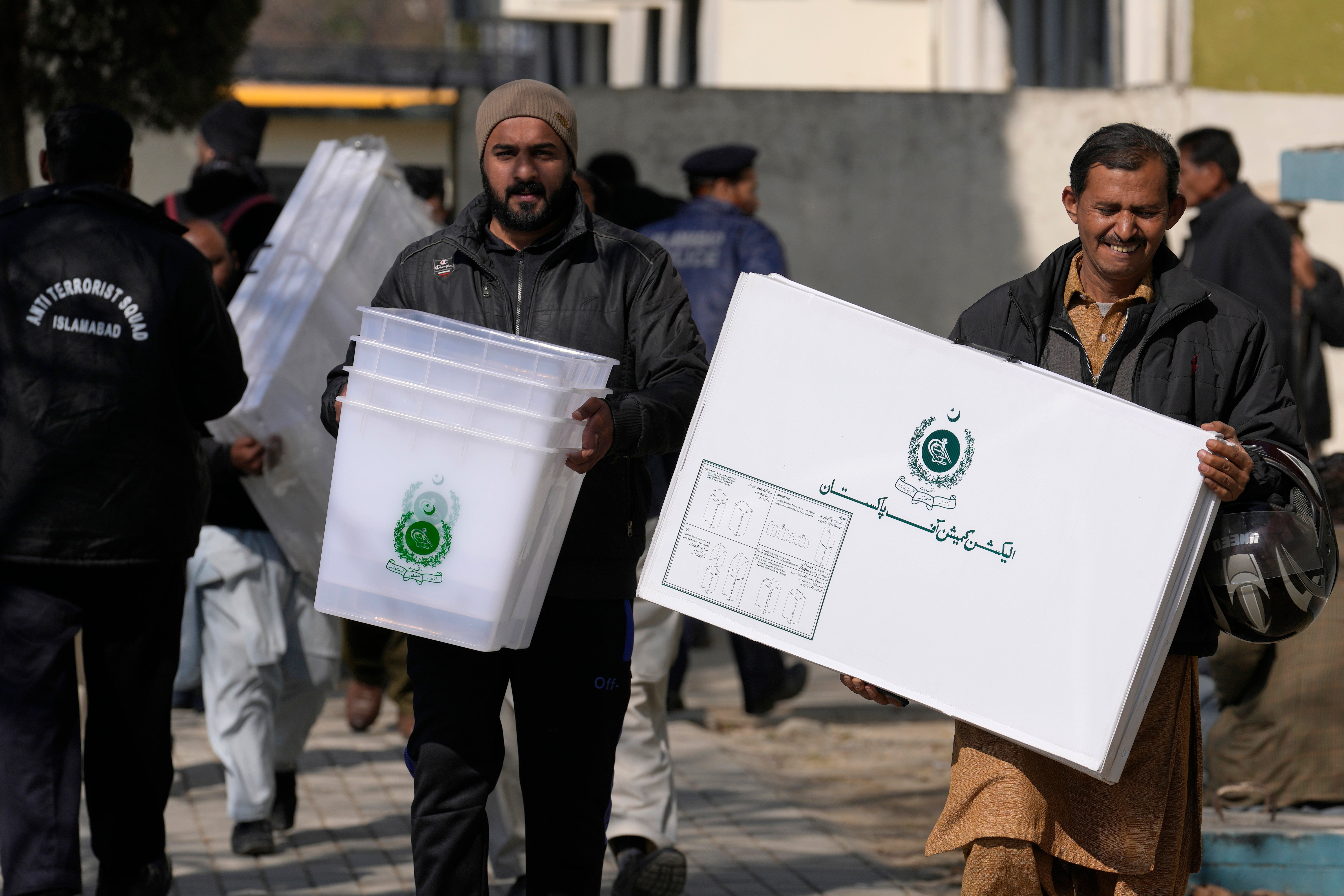 Polling staff leave after collecting polling material for Feb. 8 general elections at a collection point