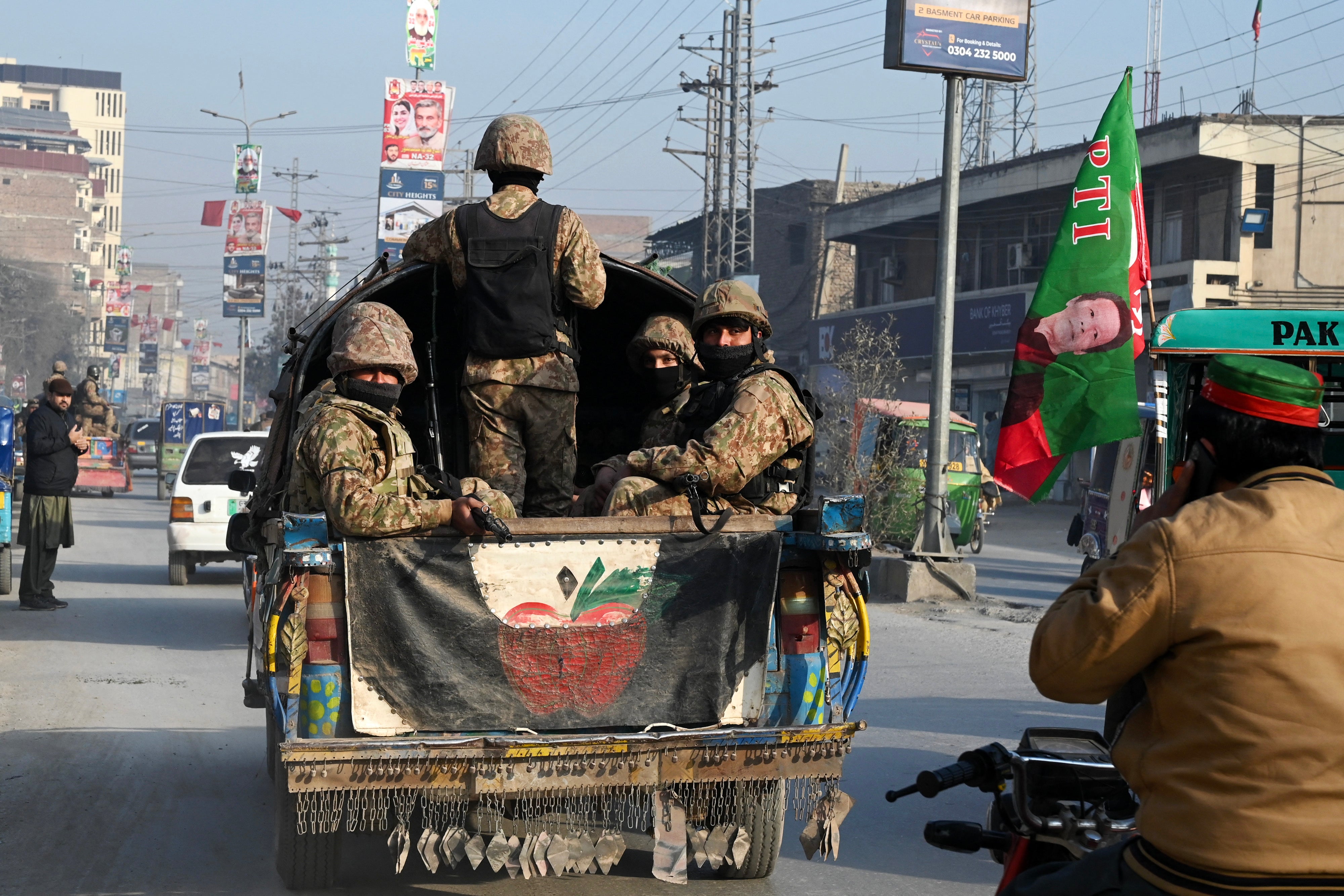 Pakistan Army personnel patrol along a road in Peshawar ahead of polls