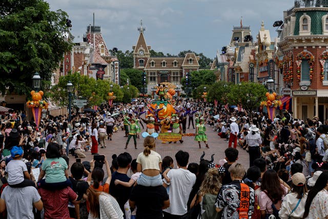 <p>Visitors watch the Halloween program featuring Disney character Mickey Mouse at a parade at Hong Kong Disneyland</p>
