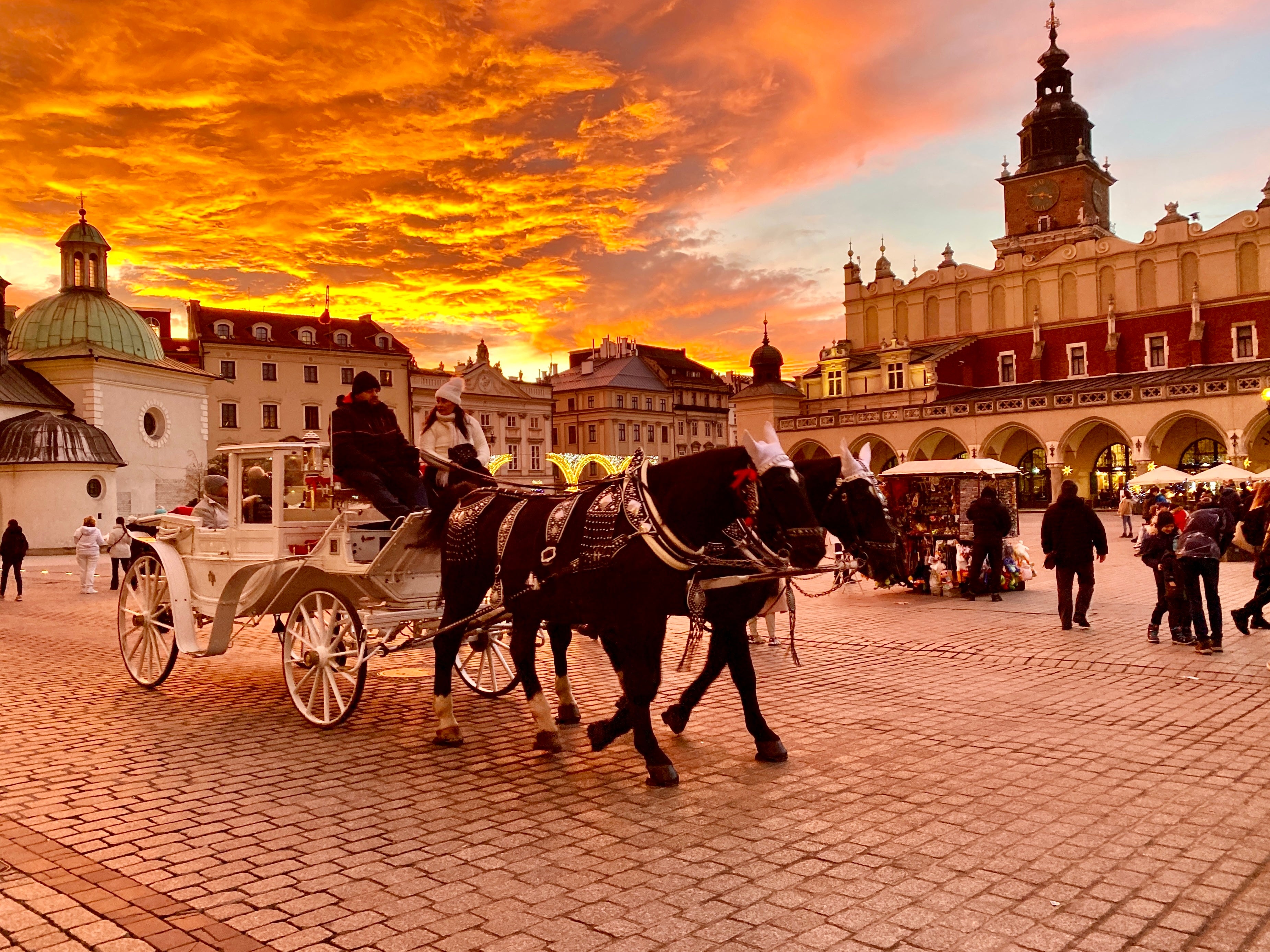 Golden hour: Winter visitors in the main square in Krakow, southern Poland