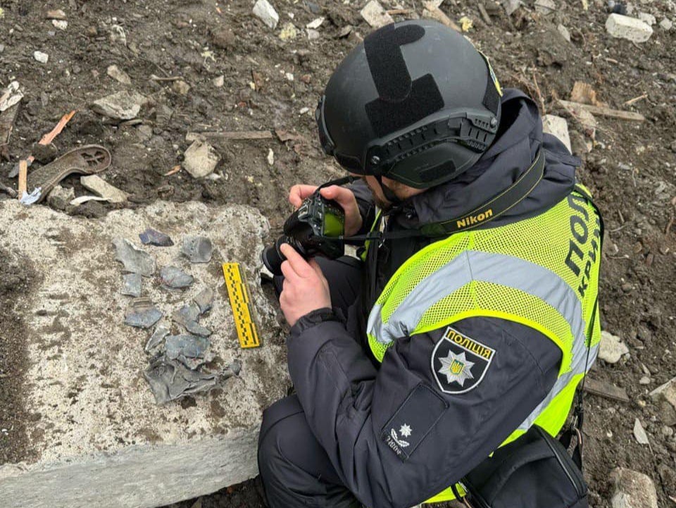 A Ukrainian police officer in Kharkiv takes pictures allegedly showing the debris of a North Korean missile