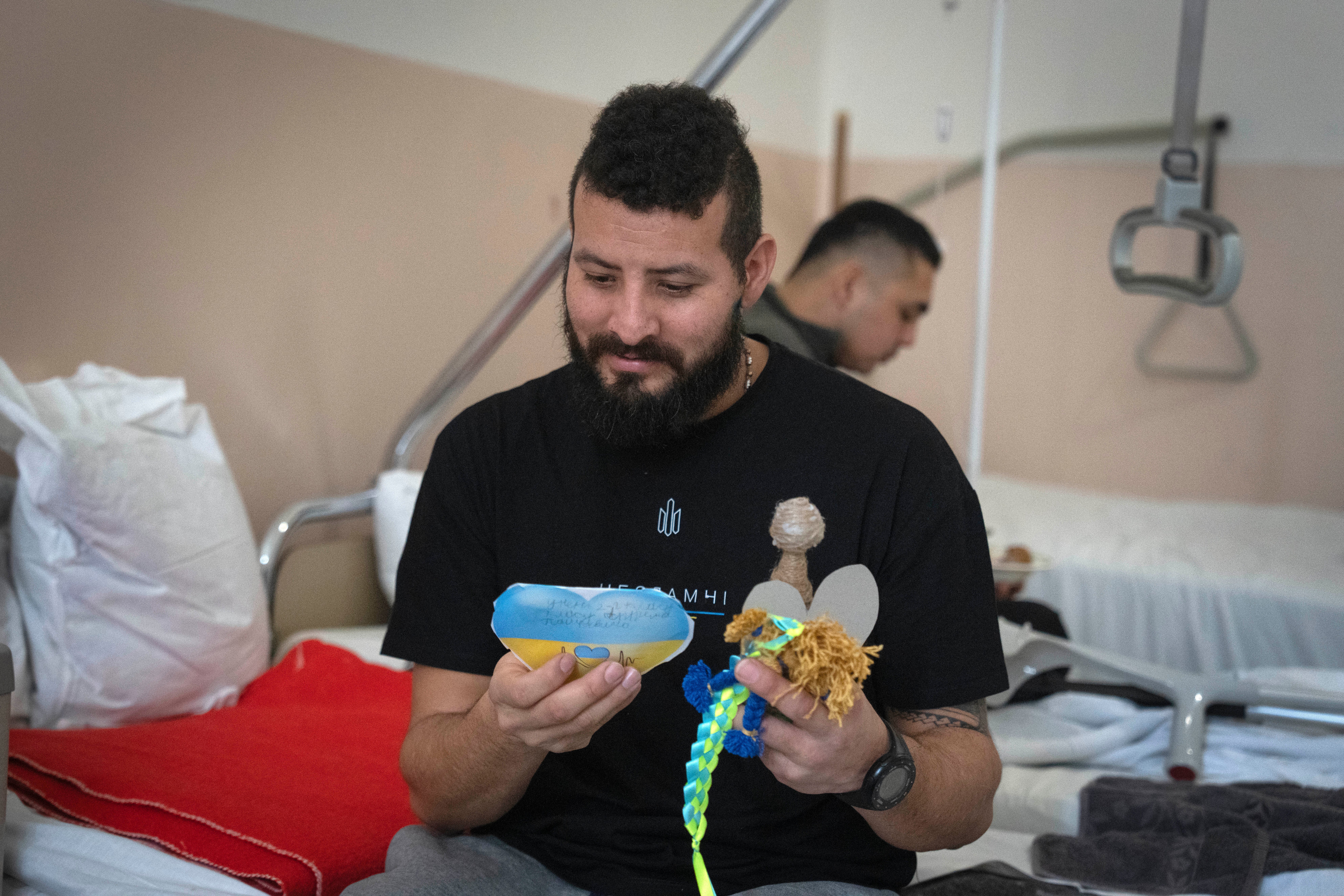 Russia Ukraine A wounded professional soldier from Medellín, Colombia who goes by the call sign of Checho, 32, smiles as he holds gifts